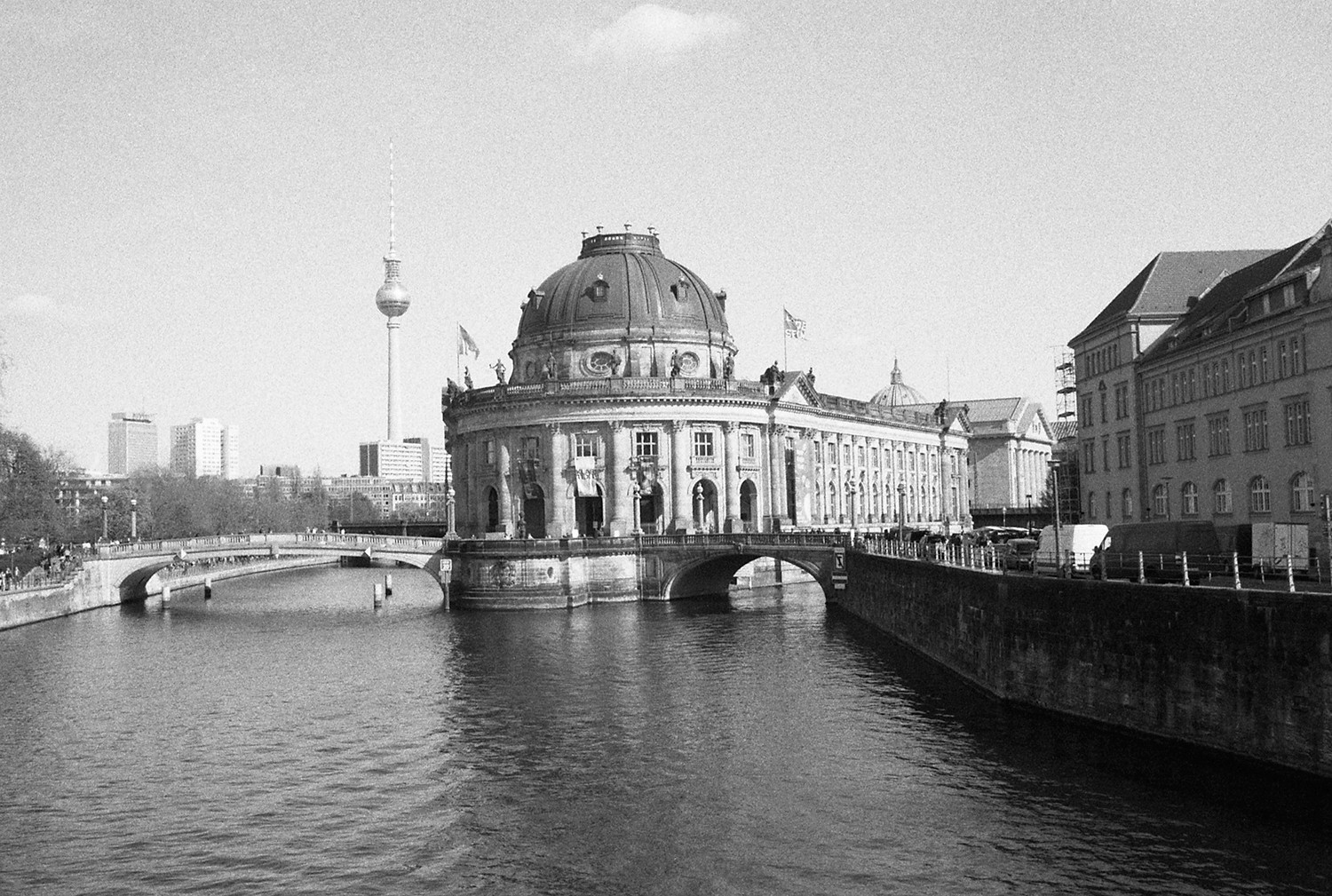 A large group photo of diverse team members gathered in an industrial-style space with arched ceiling.