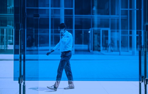 Person talking on a cell phone with a vivd blue overlay.