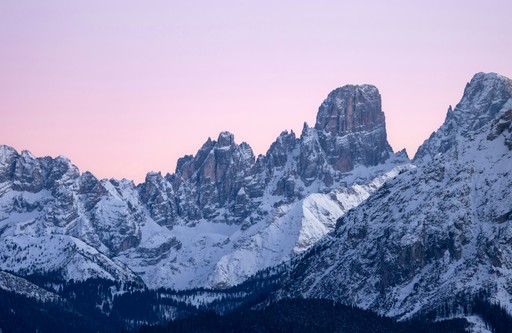 Snow-covered mountain peaks under a pastel sky