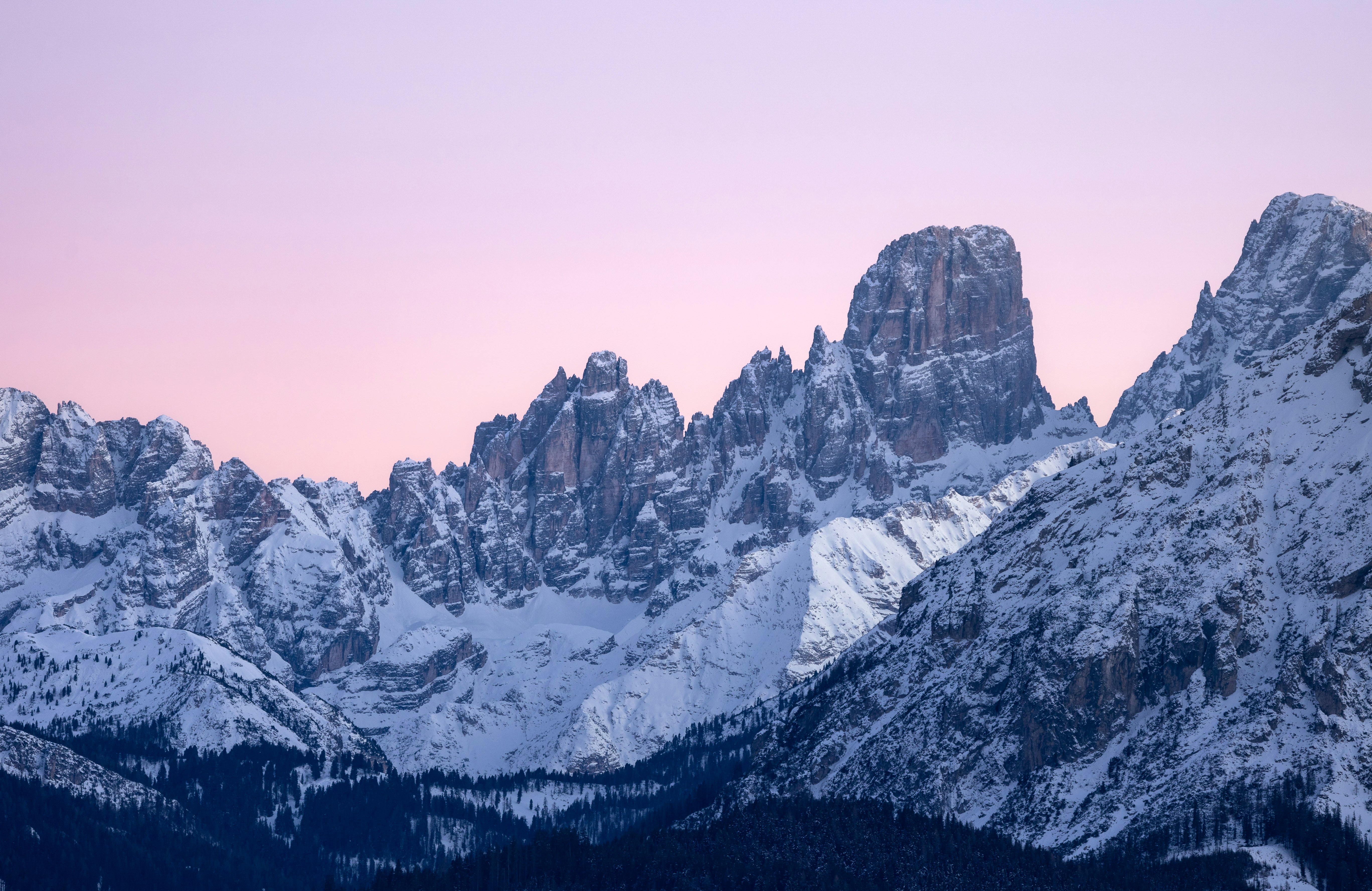 Snow-covered mountain peaks under a pastel sky