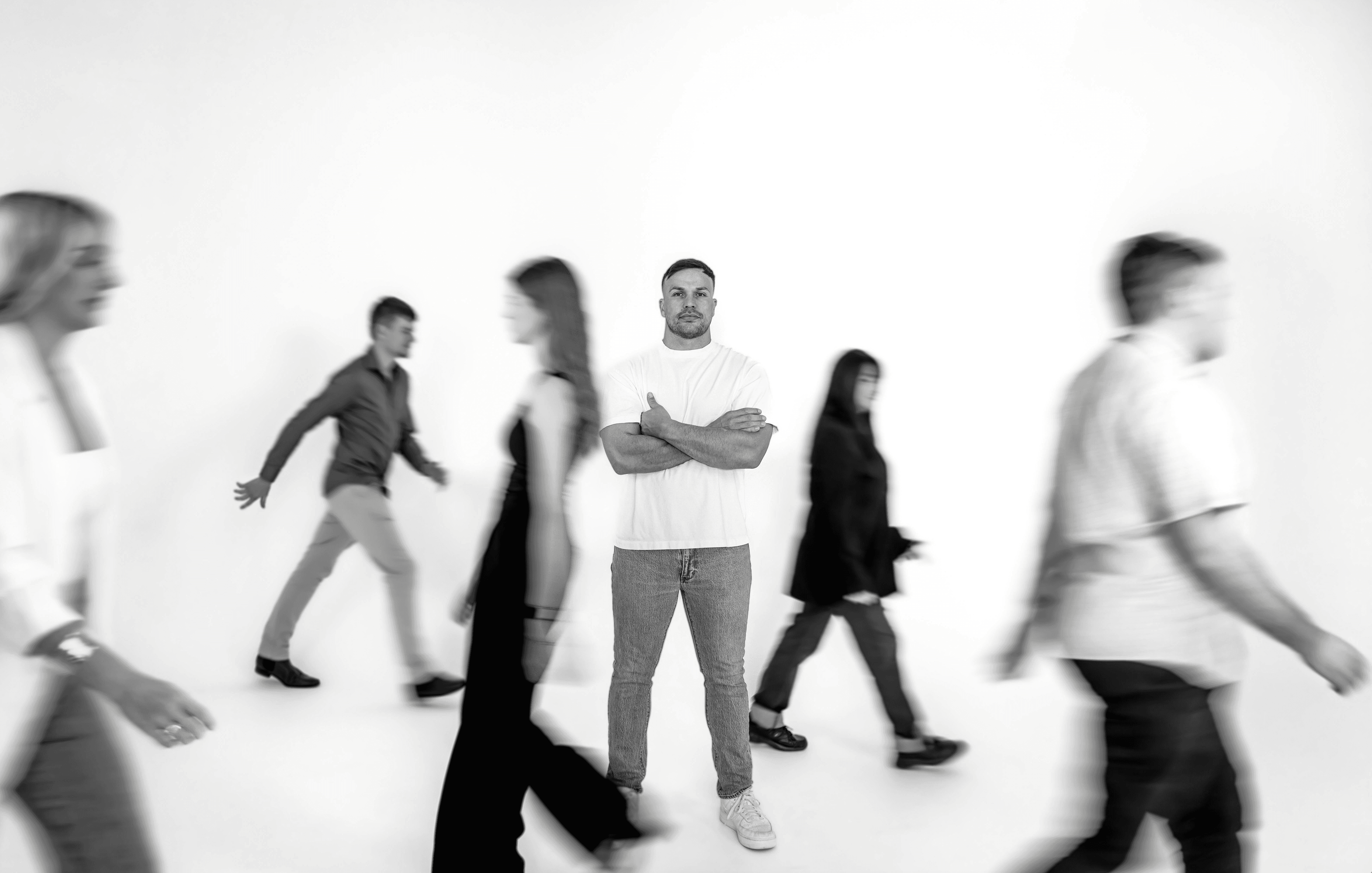 Black and white image of people working at a table with laptops, showing hands gesturing during discussion of digital content displayed on screens, with fabrica® logo in the corner.
