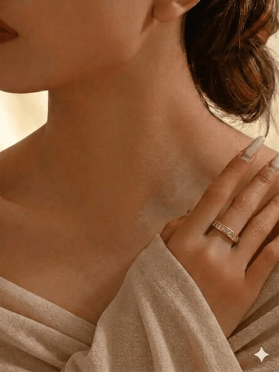 A close-up of a woman's shoulder and neck, with her hand gently resting on her shoulder. Soft lighting highlights her skin.