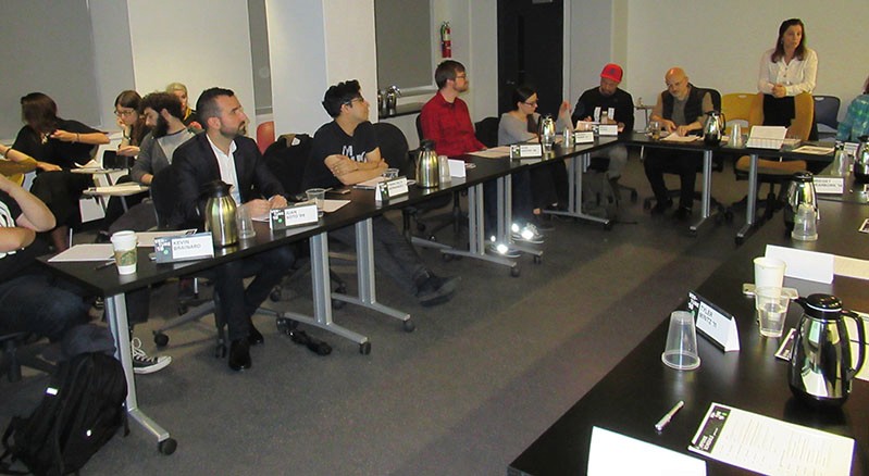 A photo of a group of people sitting at a conference table.