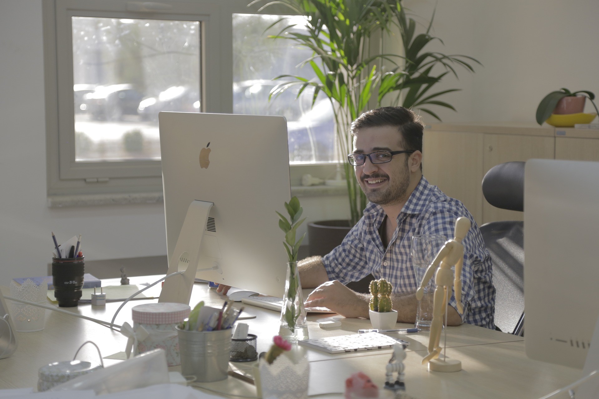 Plexable team member smiling while working at an iMac in the studio