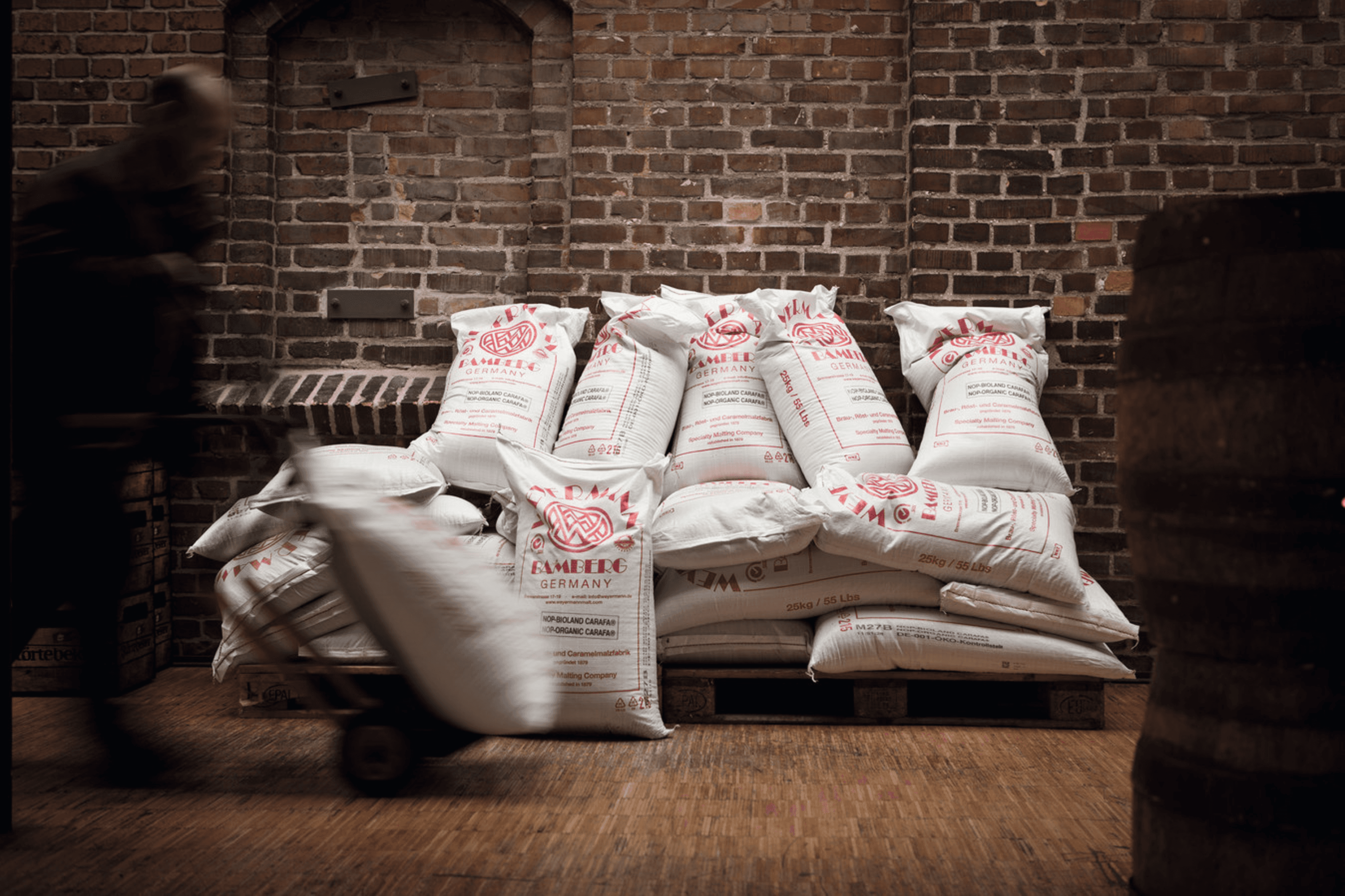 Sacks of malt are stacked on pallets.