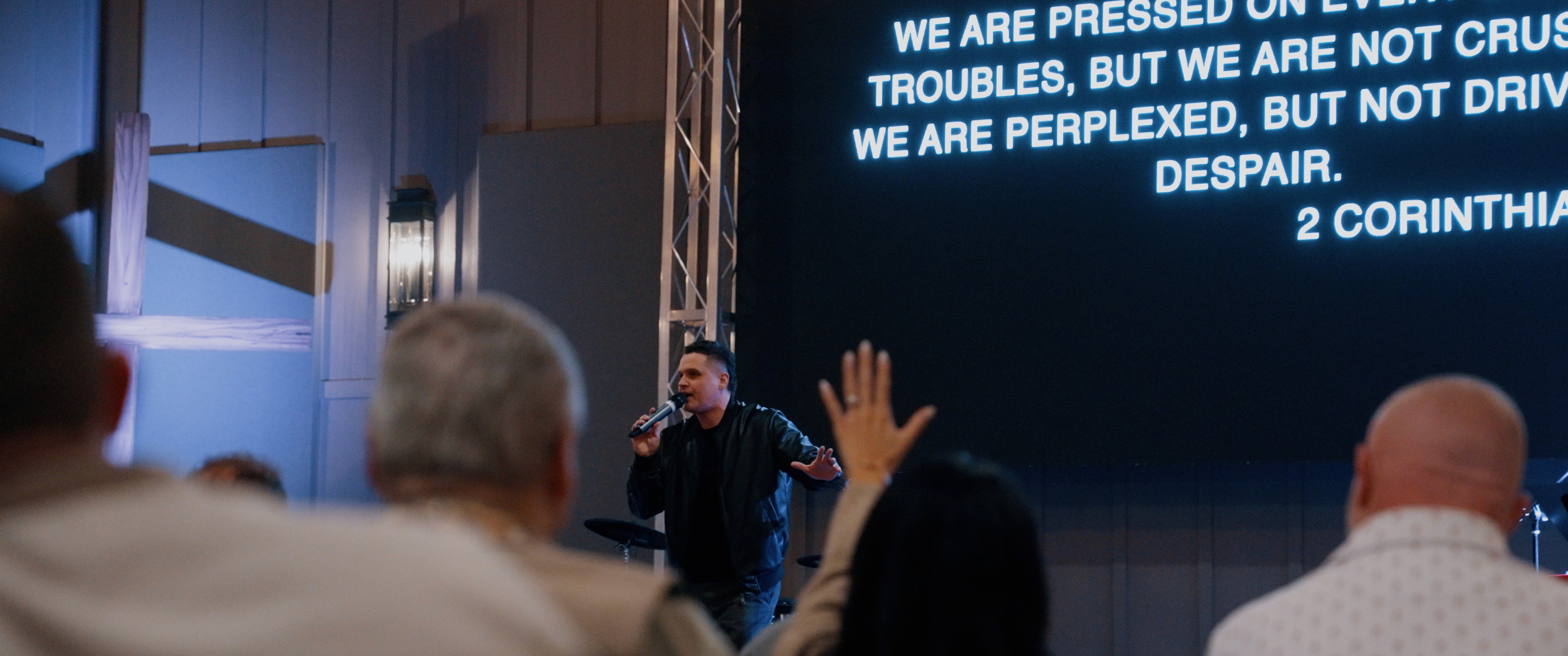 woman in gray coat singing on stage