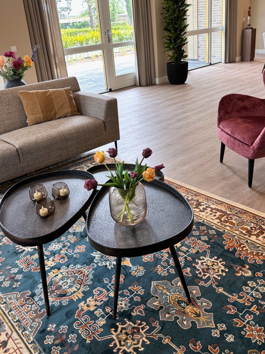 zithoek met groep tafeltjes en vintage vloerkleed 