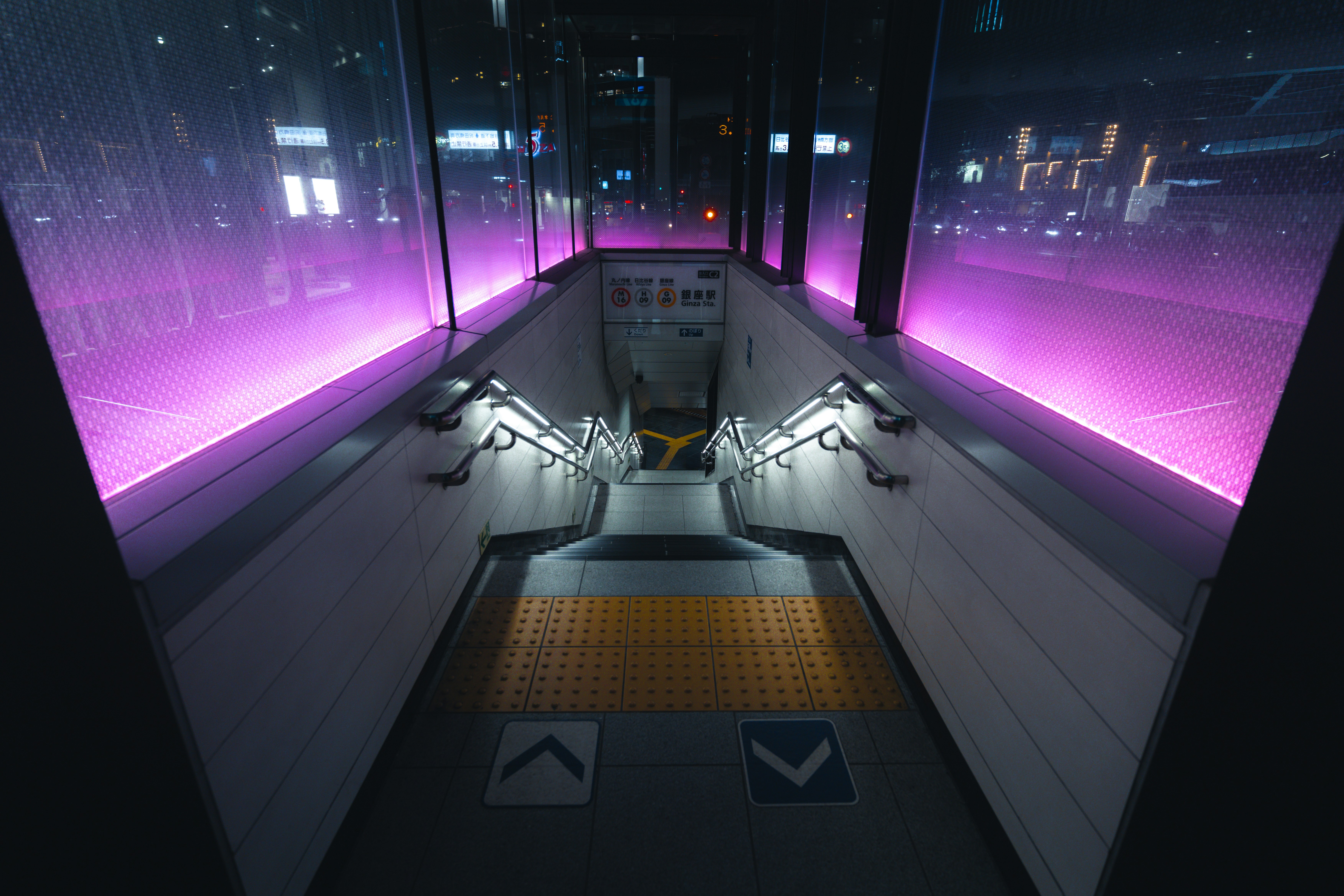 A train station with purple lights on the walls