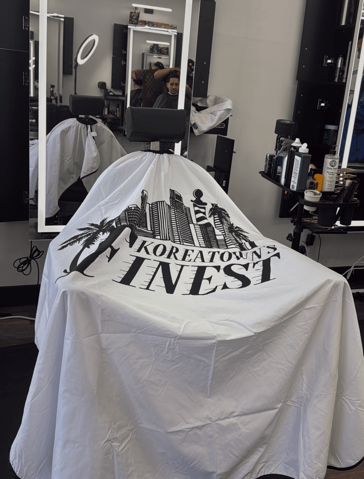 Barbershop char with Koreatown's Finest cape. 