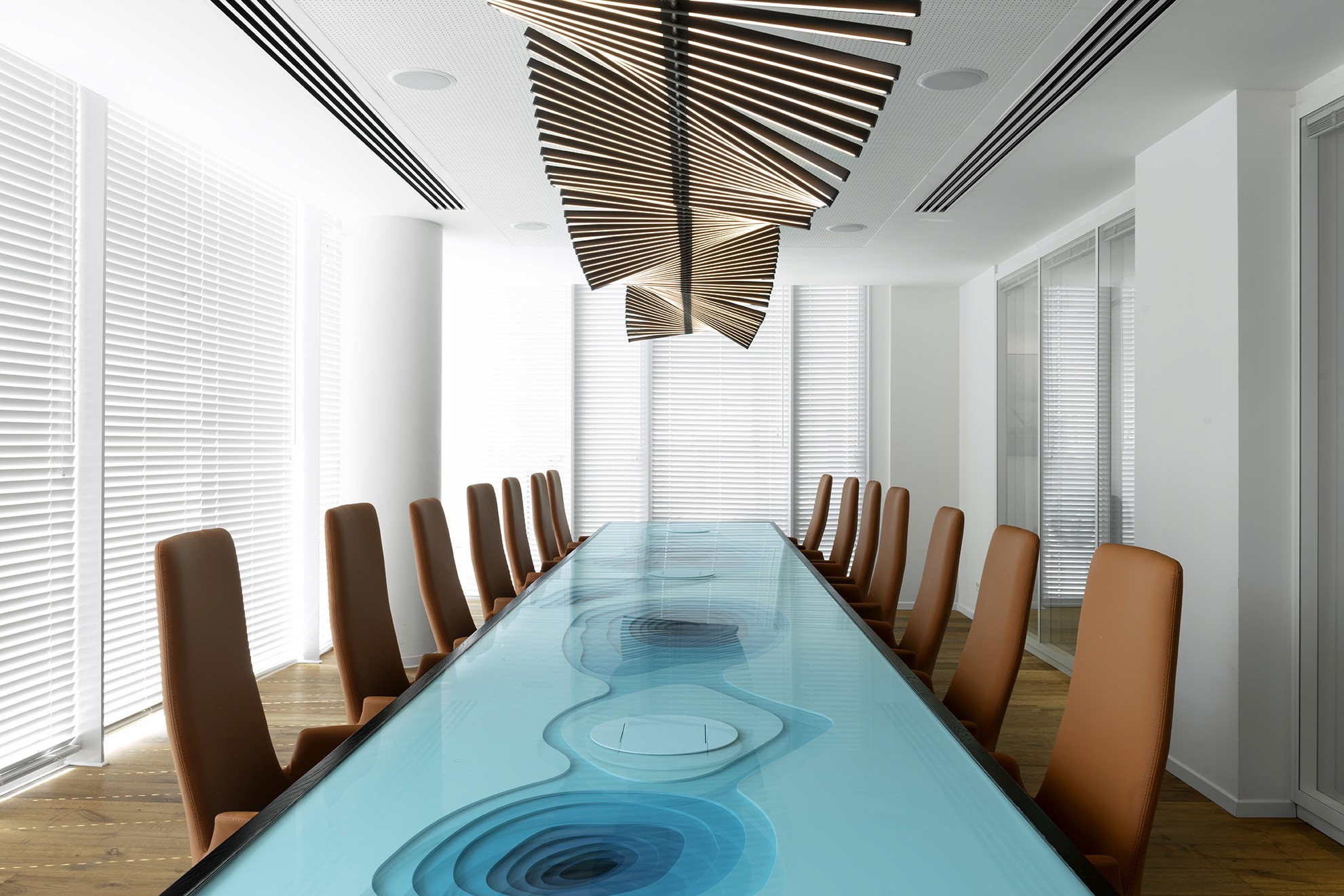 עיצוב טוטאלי: חדר הישיבות המרכזי עם גוף תאורה פיסולי מעץ המרחף מעל שולחן הטופוגרפיה, ויוצר דיאלוג בין התקרה לשולחן.