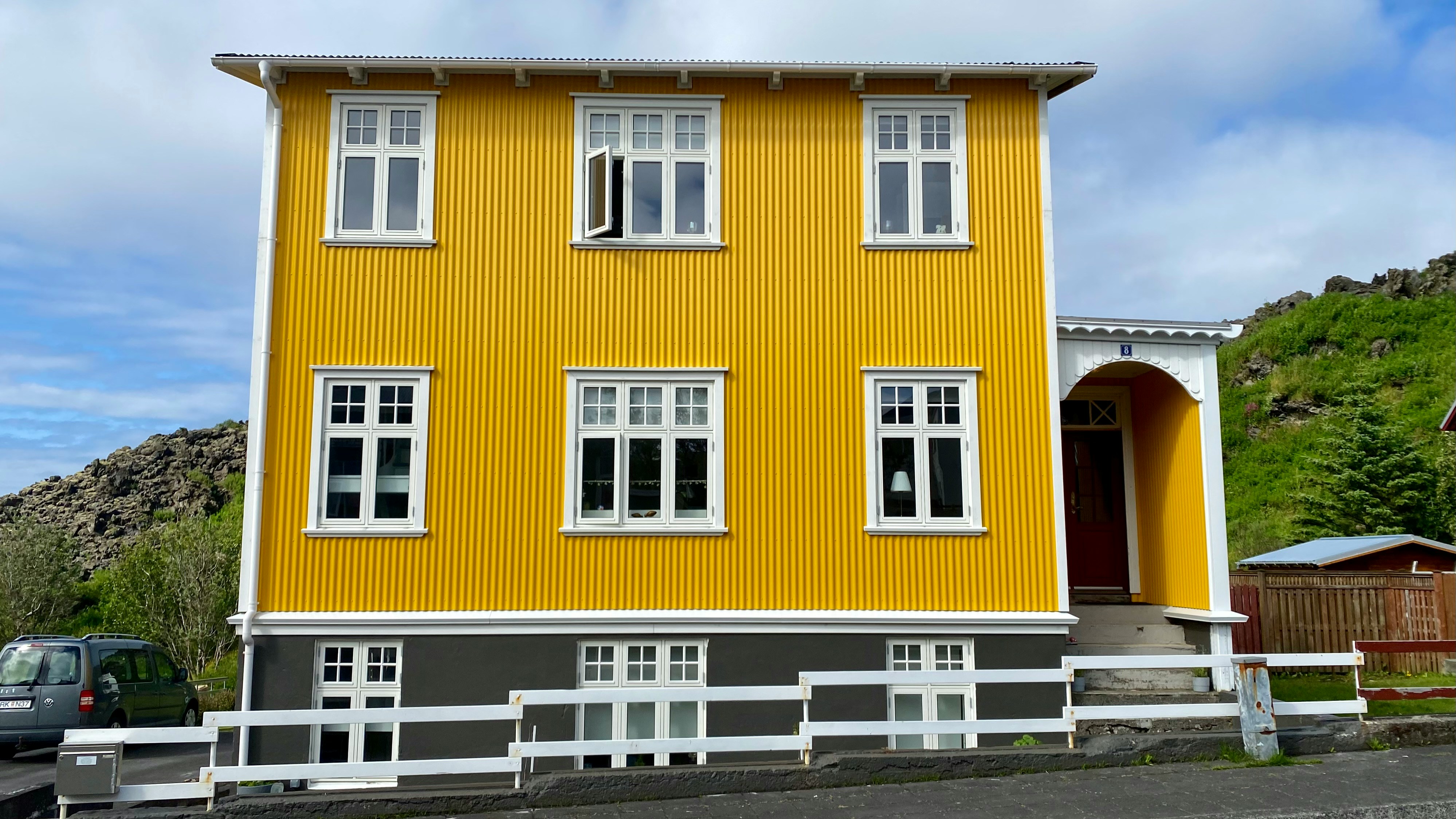 a yellow house with a fence