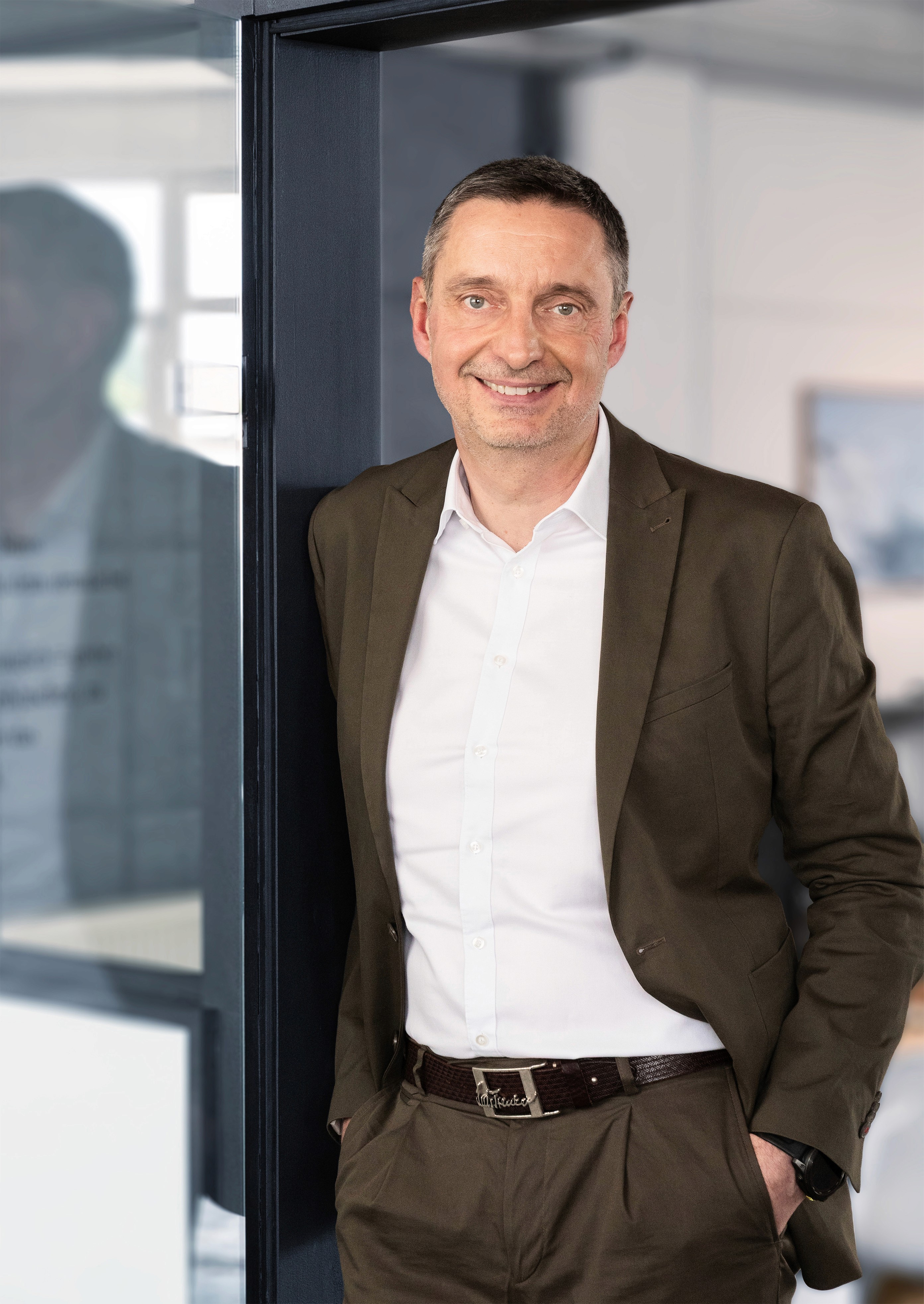 Stefan Bischo, Gründer von Leadtransform, steht lächelnd im Büro