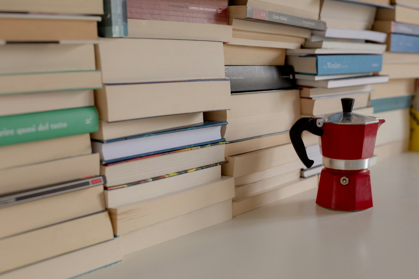 Books gathered beside a red coffee pot