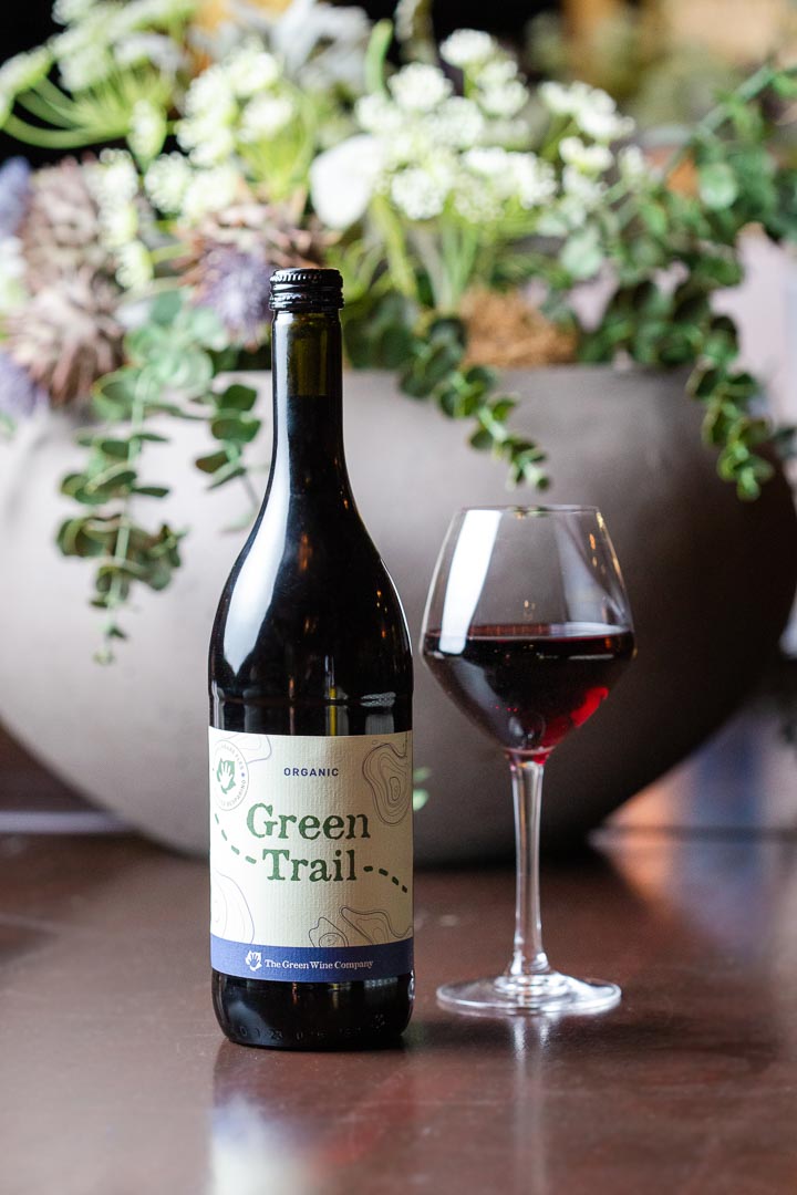 Een fles van de Green Wine Company voor een plant met een ingeschonken glas