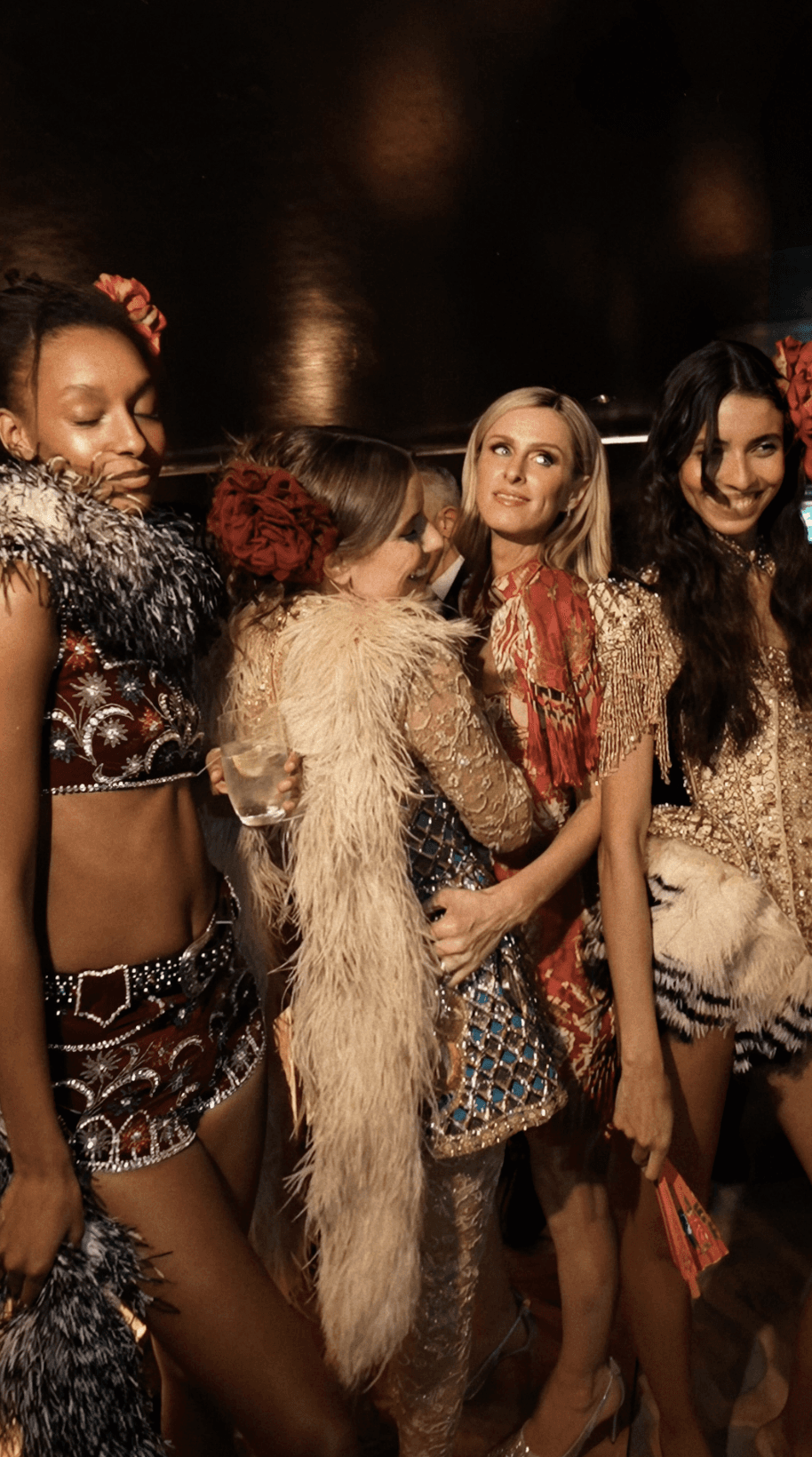 Bride sitting on ground against wall, groom standing nearby