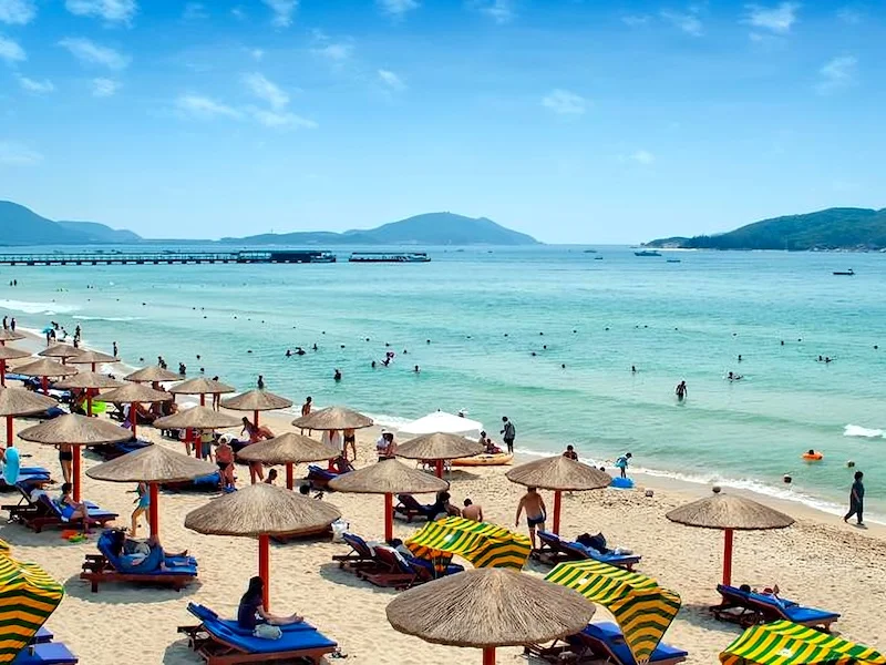 Sanya beach with umbrellas and people