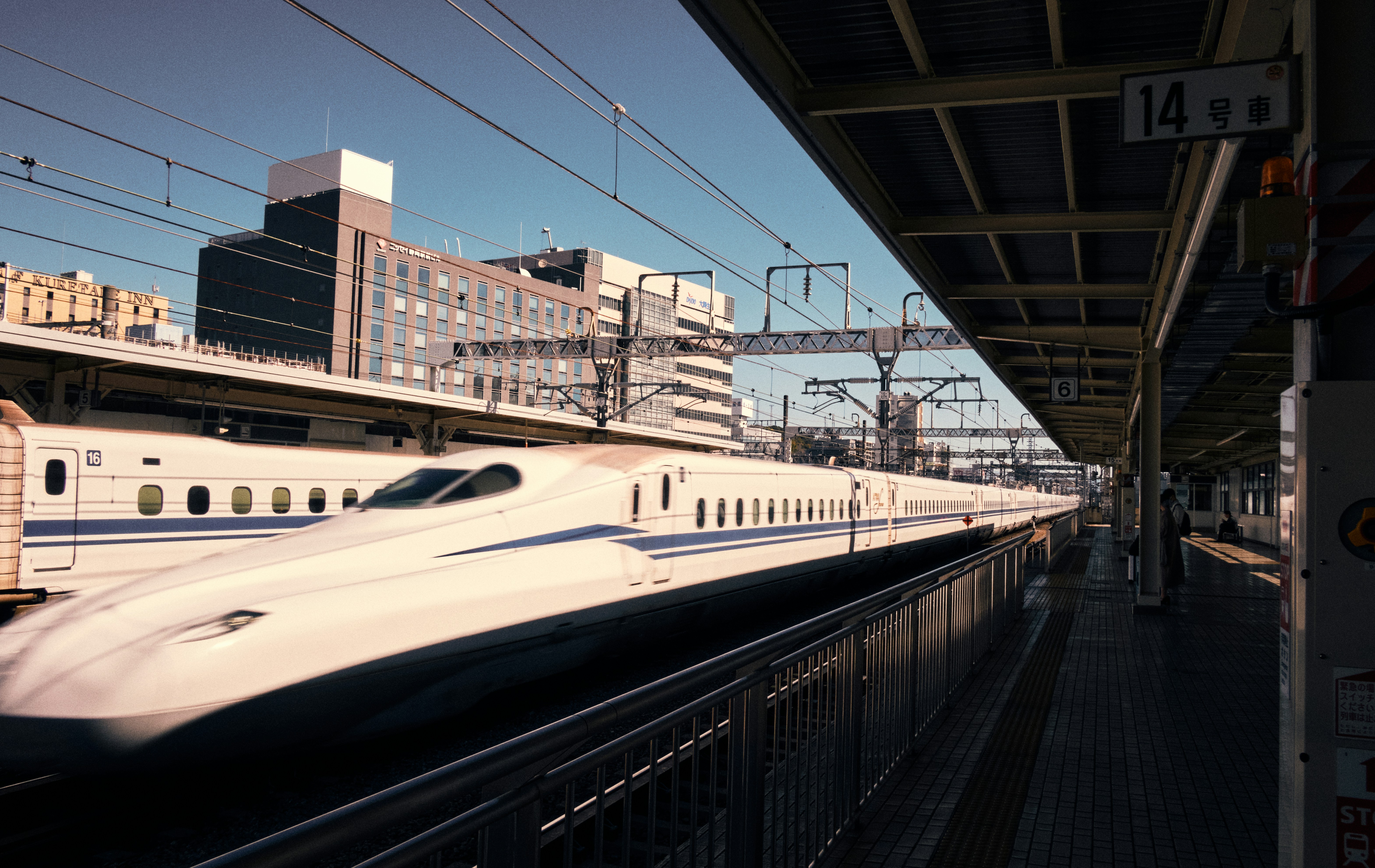 A white bullet train at a station platform