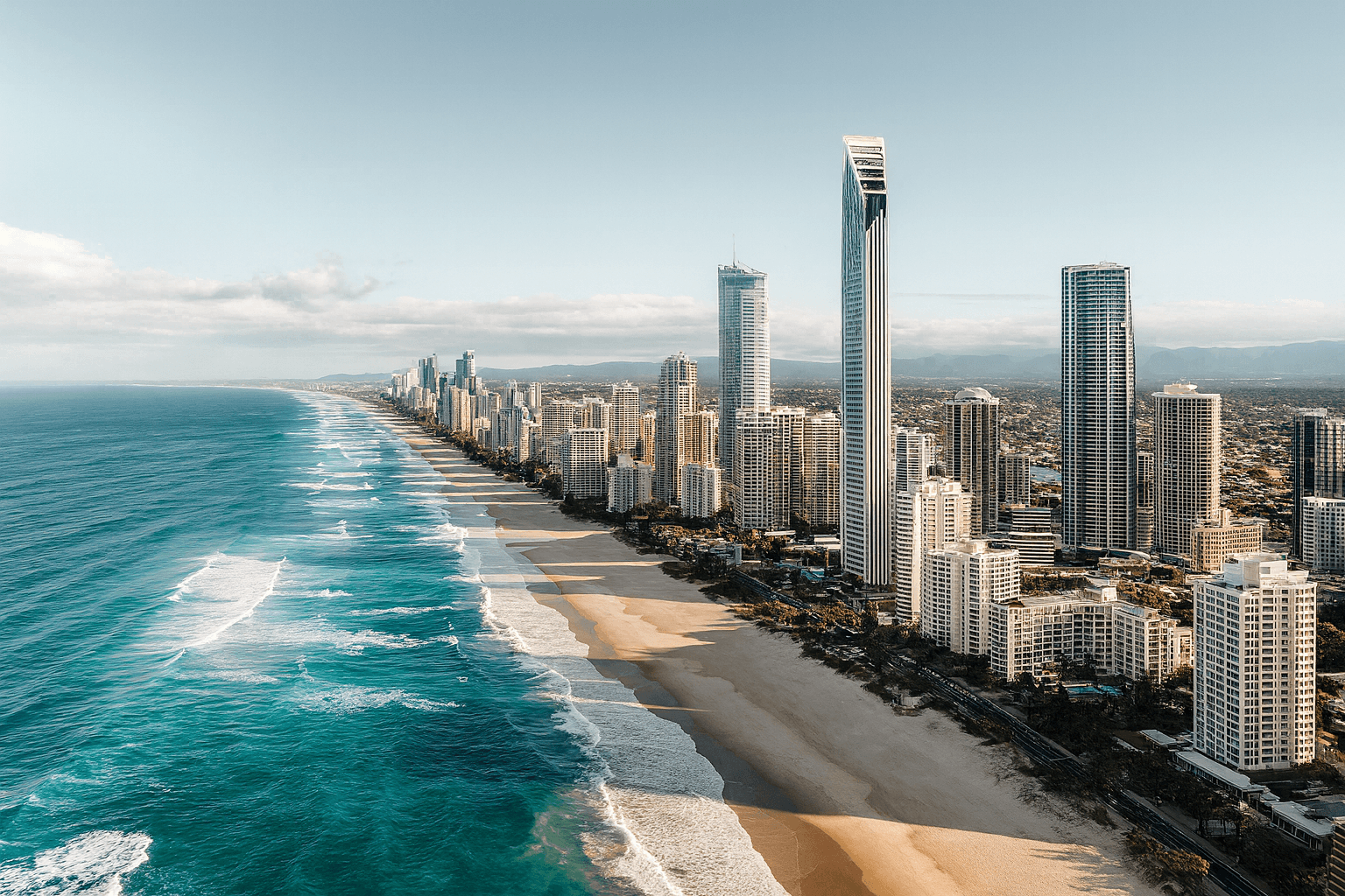 A beautiful beach with palm trees and a mountain in the background