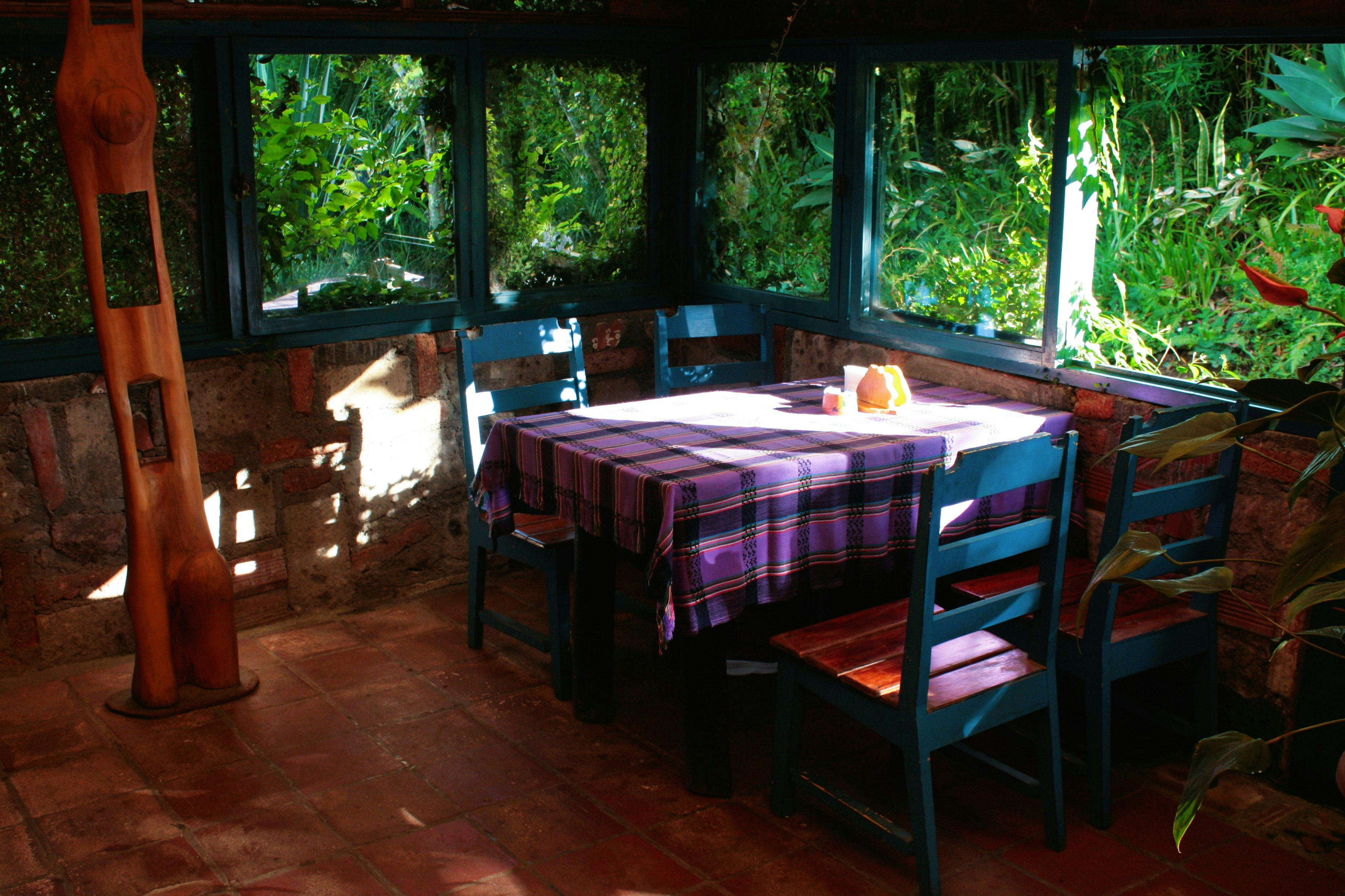 A table and chairs in a room with plants