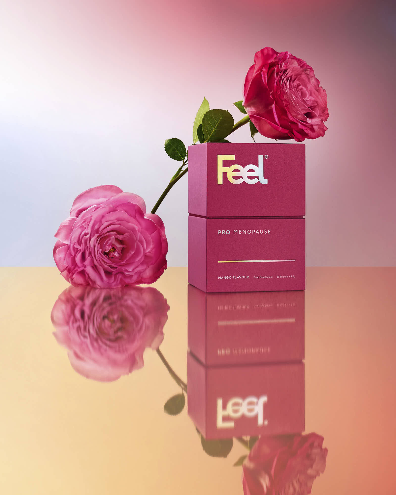 A pink bottle of cosmetic product on a reflective surface, accompanied by bright pink flowers against a gradient background.