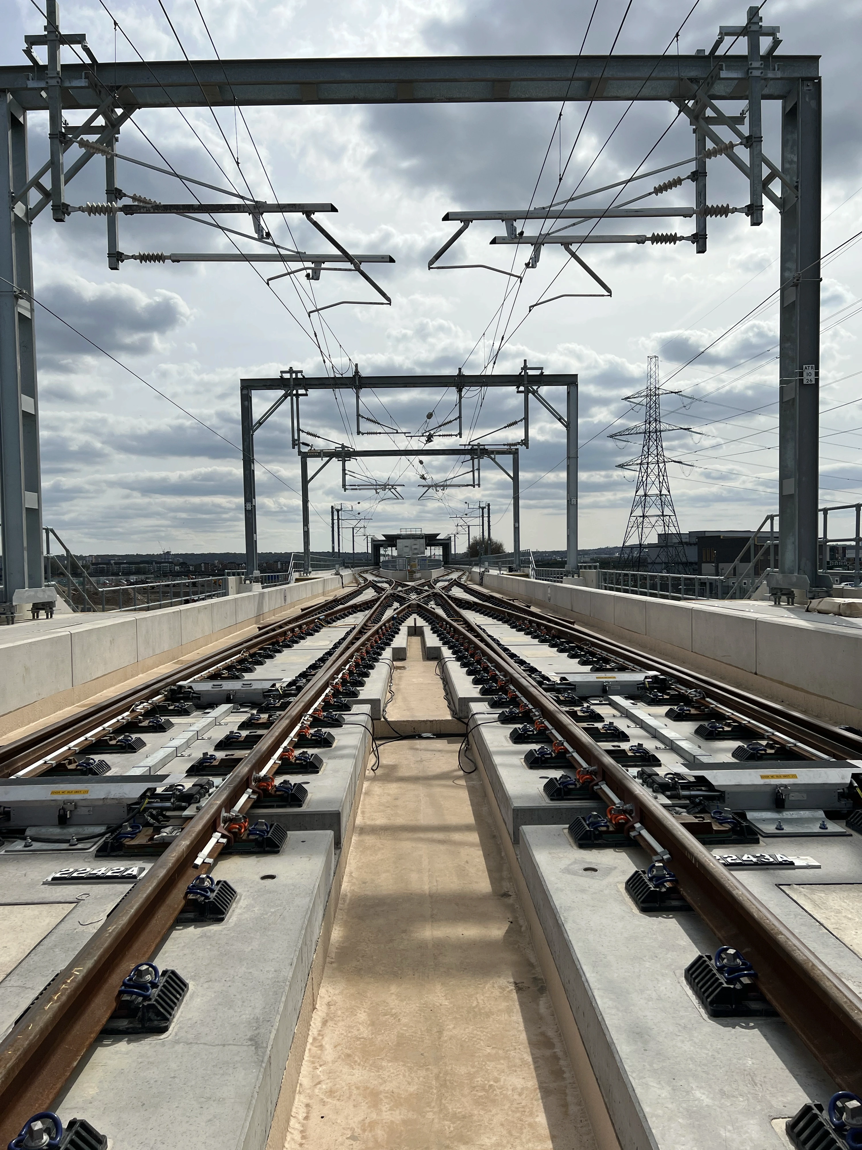 Architectural rendering of a modern residential complex with orange cladding and large balconies, set in landscaped gardens