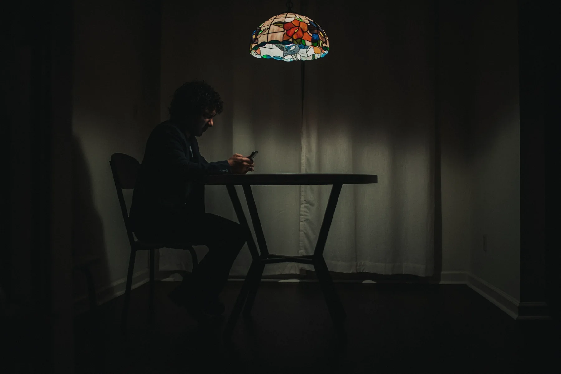 A designer working late at a small table under a lamp