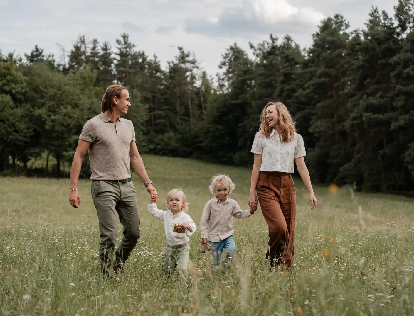 Rodina se dvěmi dětmi na procházce po zelené louce