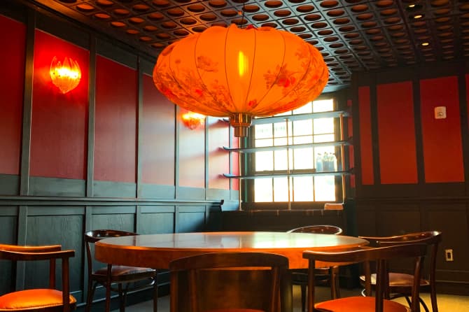 A large orange paper lantern over a wood table