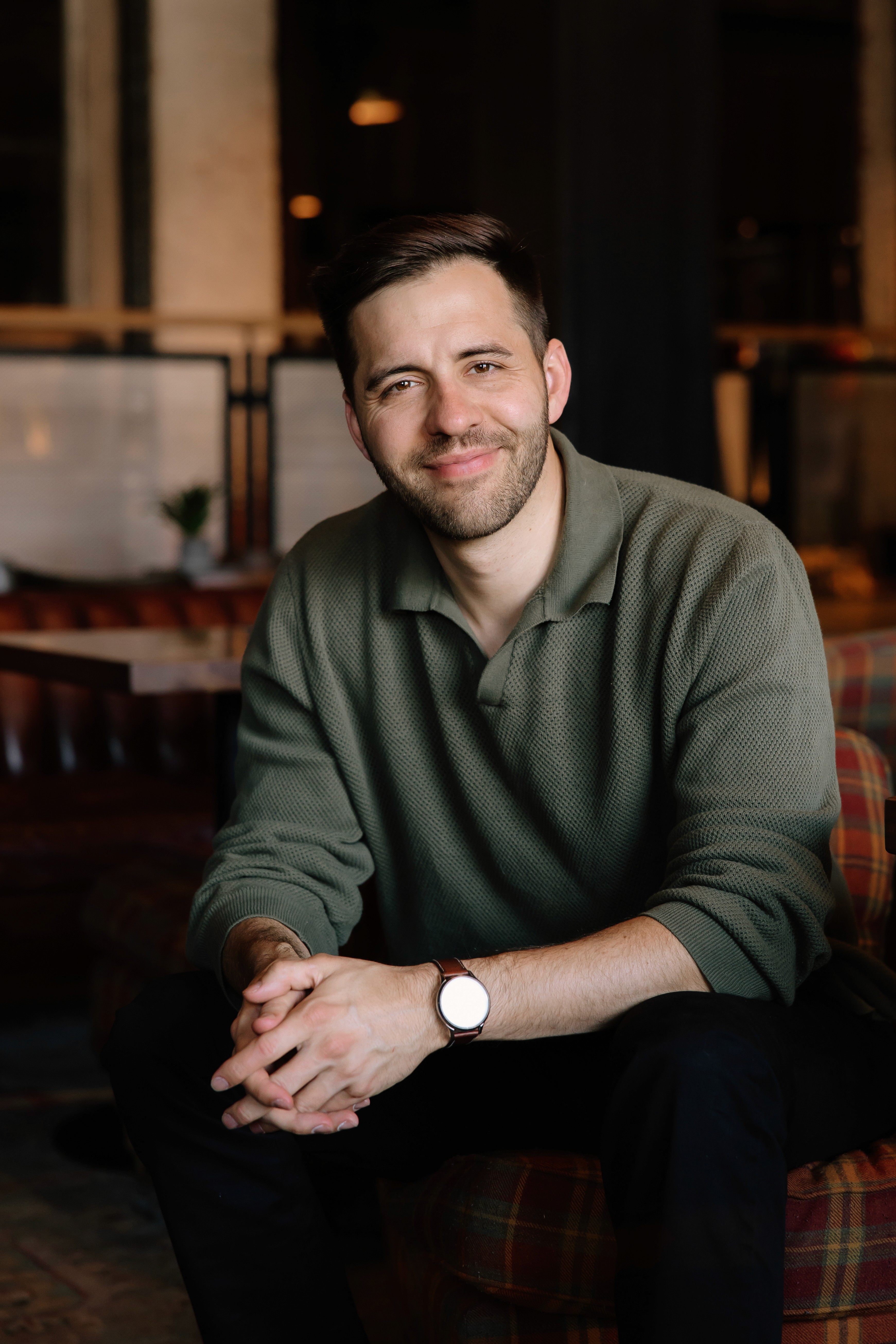 Modern office interior with glass walls, wooden accents, and a person walking up a staircase in motion blur.