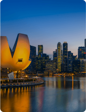 City skyline at night with reflection in water.