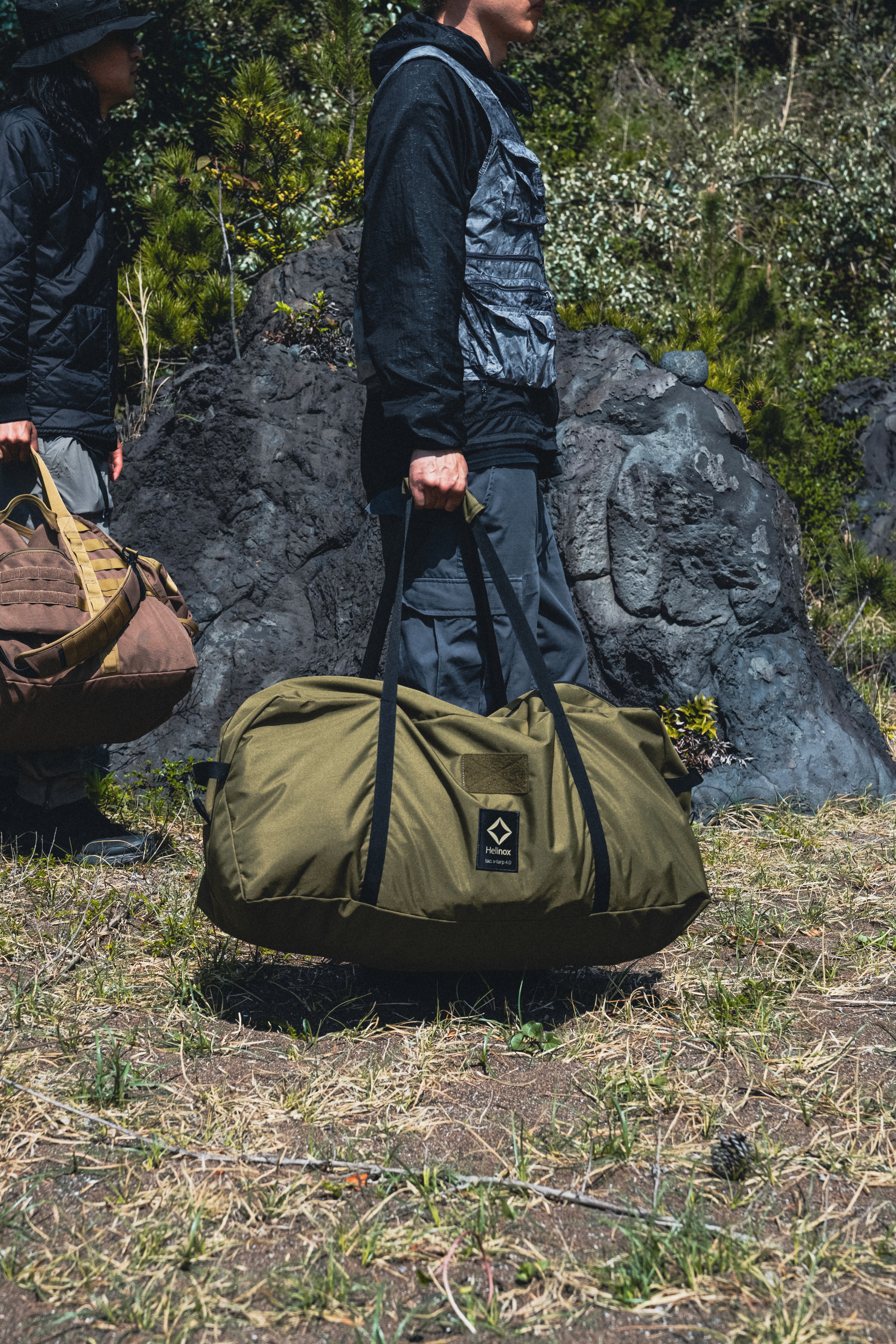 Un homme tient un grand sac Helinox en pleine nature
