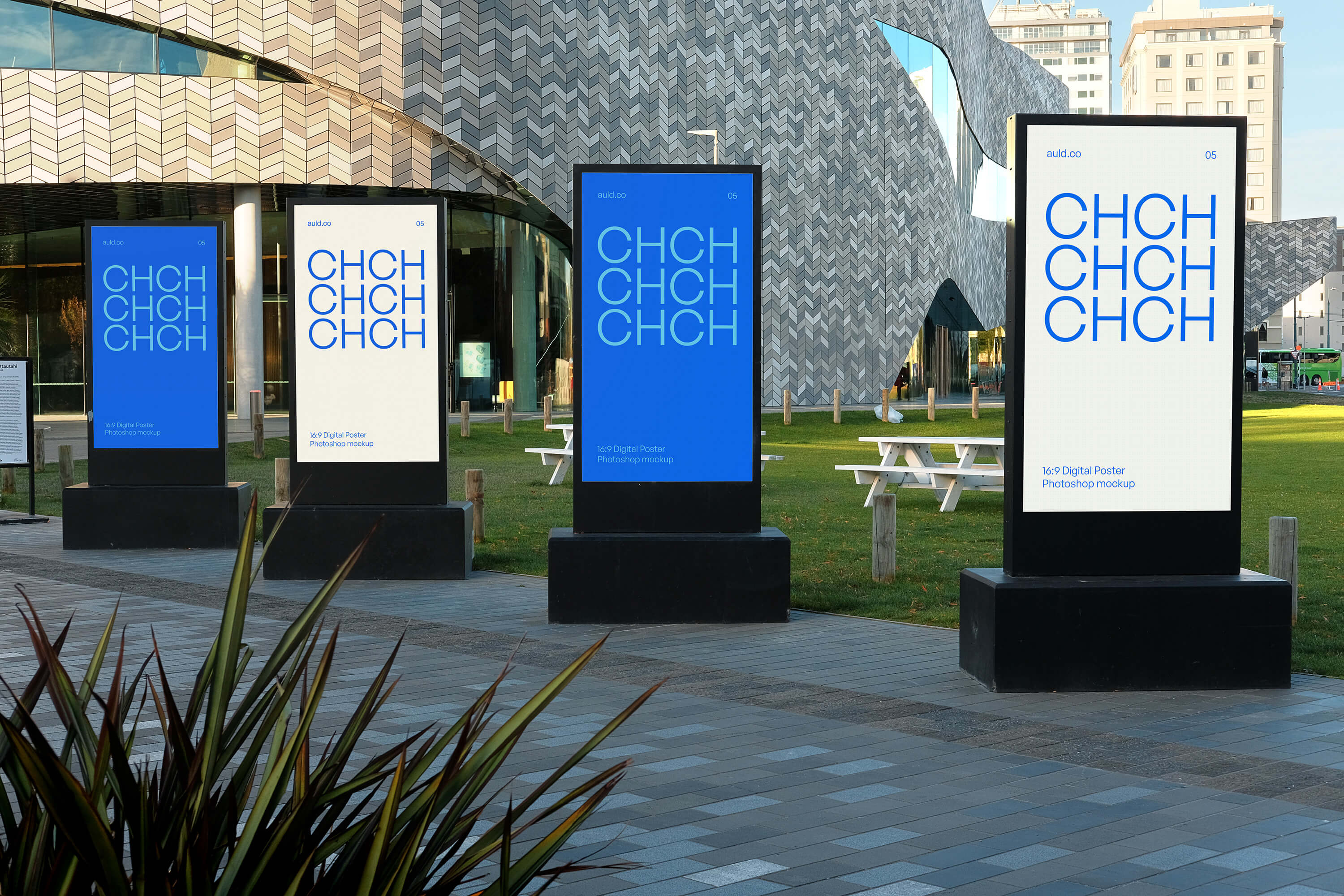 CHCH mockup artwork shown across four digital display panels outside a modern building