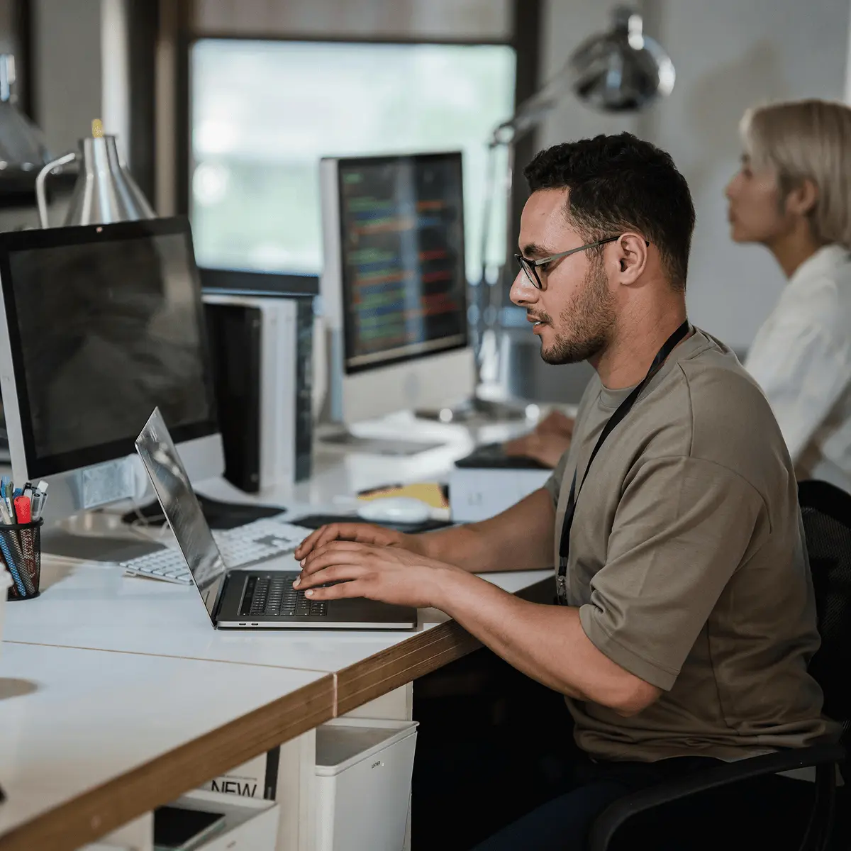 Software developer using a laptop in a modern office.