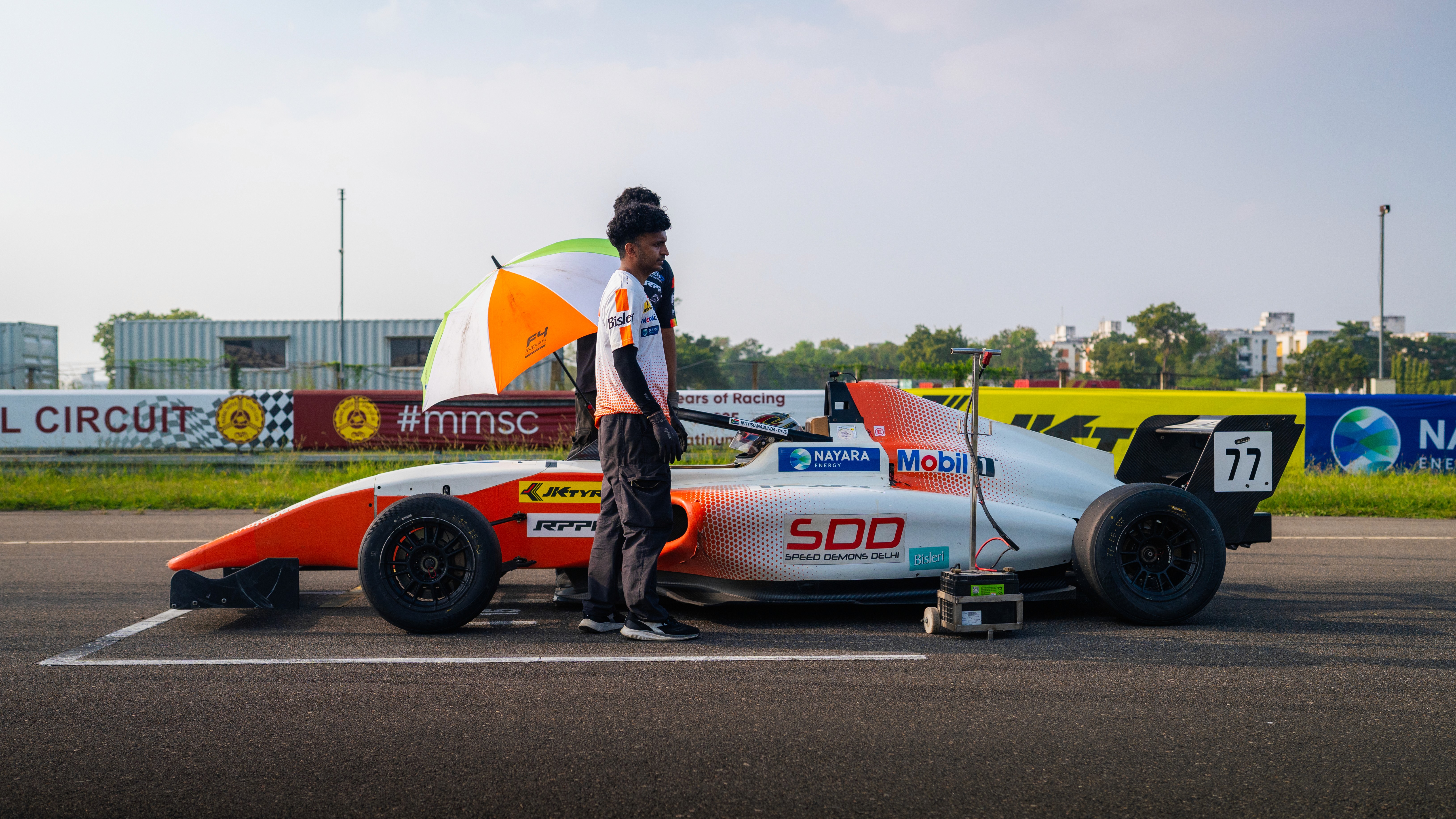 A yellow race car driving down a road
