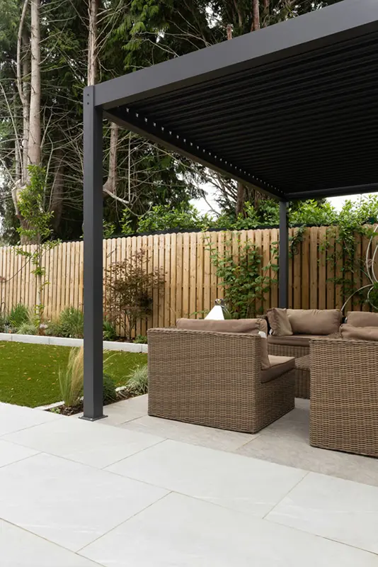 Anthrazit Lamellendach über Rattan-Lounge auf einer Gartenterrasse