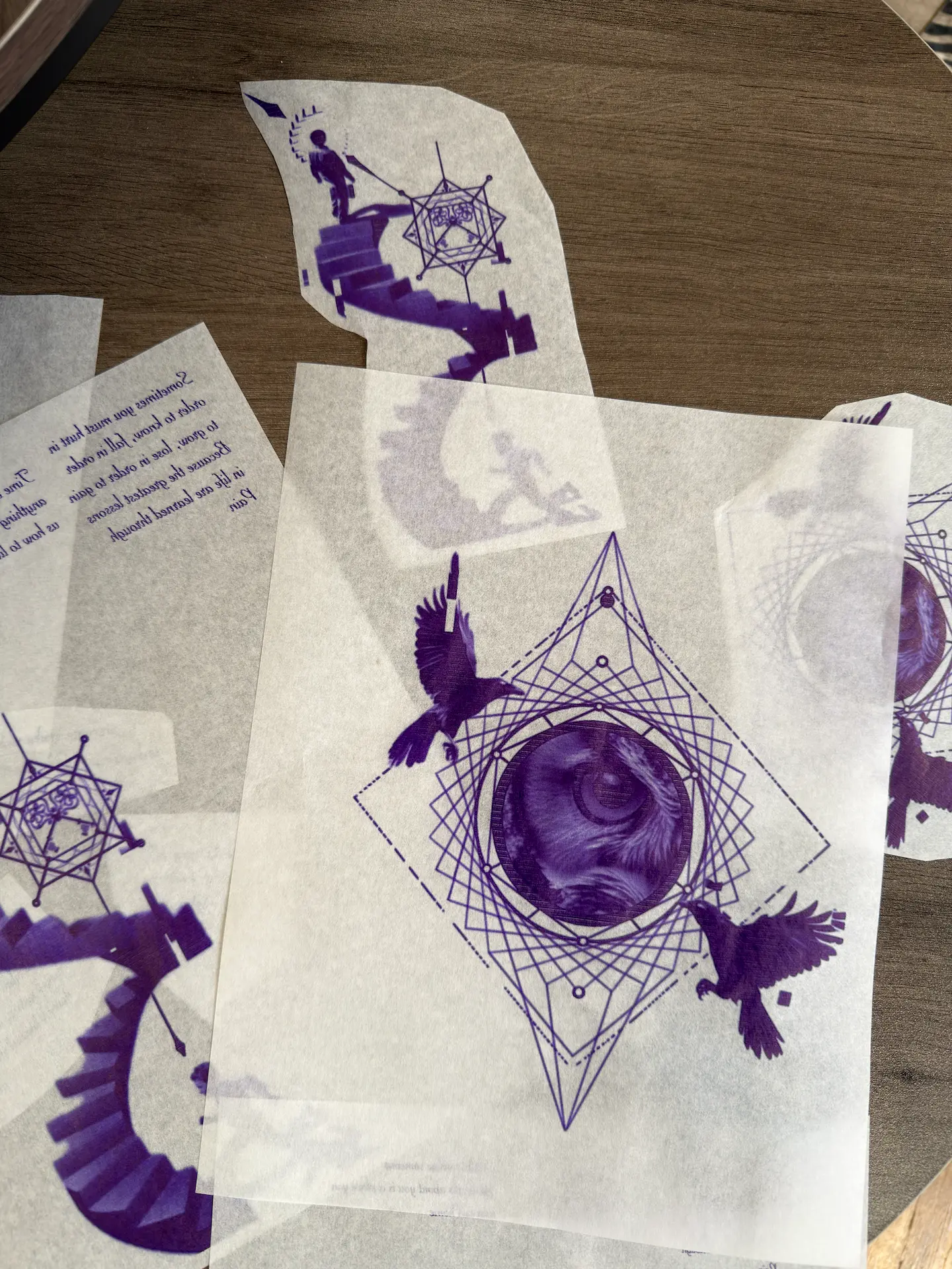 Detailed view of custom bespoke tattoo stencils featuring surreal geometric elements, stairs, and raven designs, prepared for a private micro-realism session.