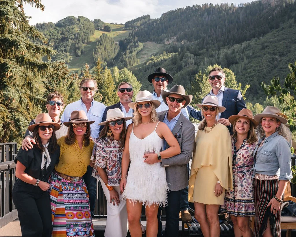 Wedding guests posing together with mountains behind them