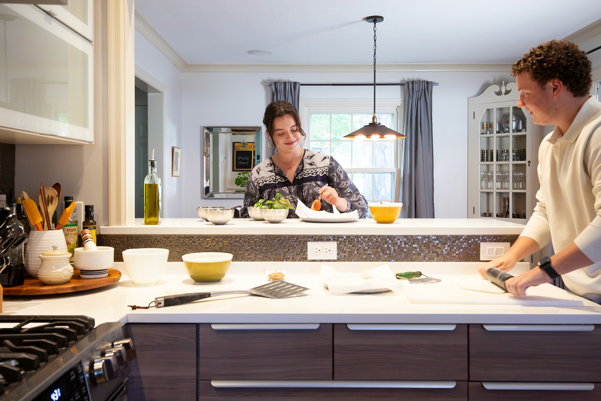 Homeowners cooking together at the island in their Diamond Lake kitchen, Minneapolis