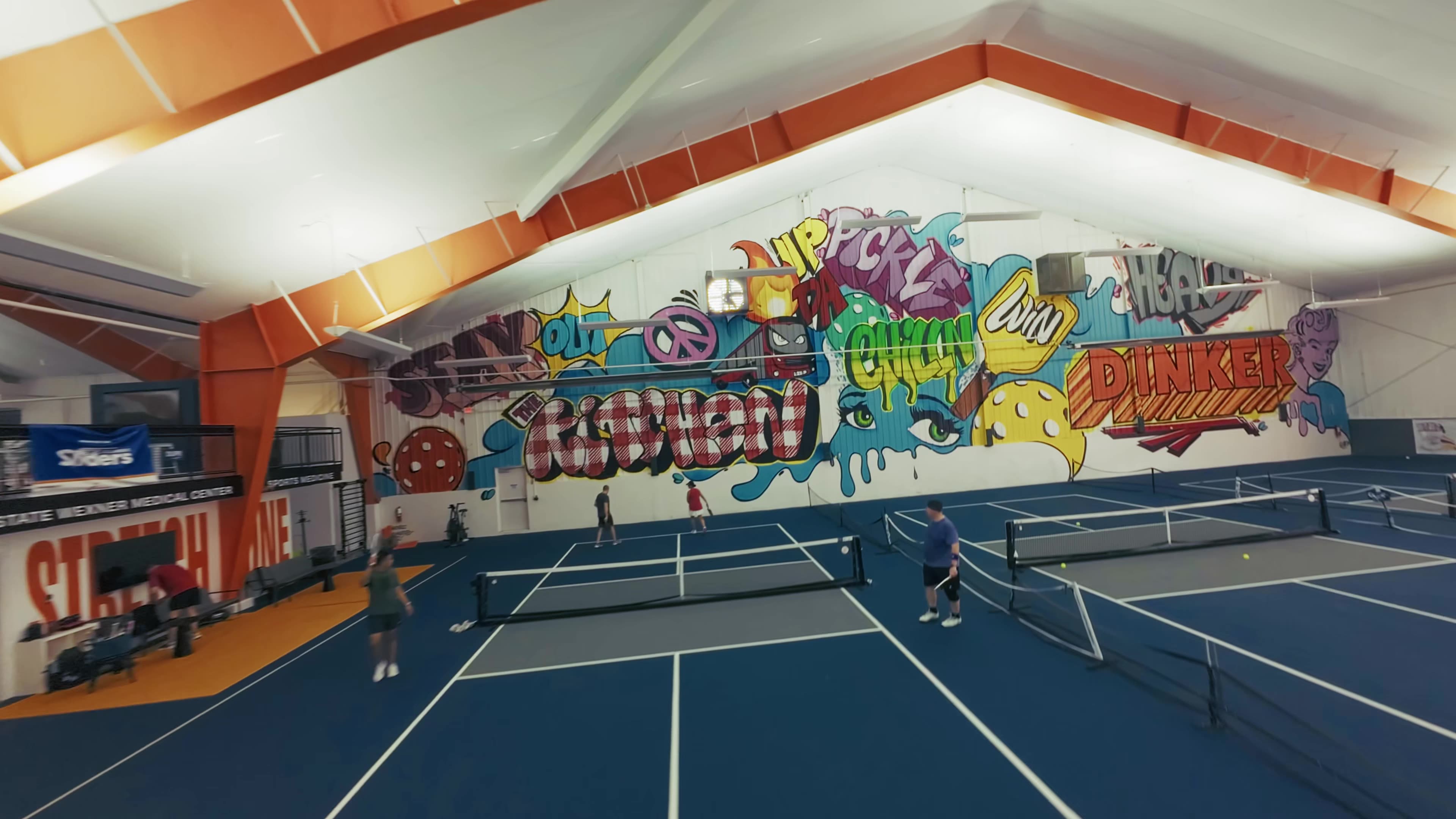 Indoor pickle ball facility with graffiti on the wall