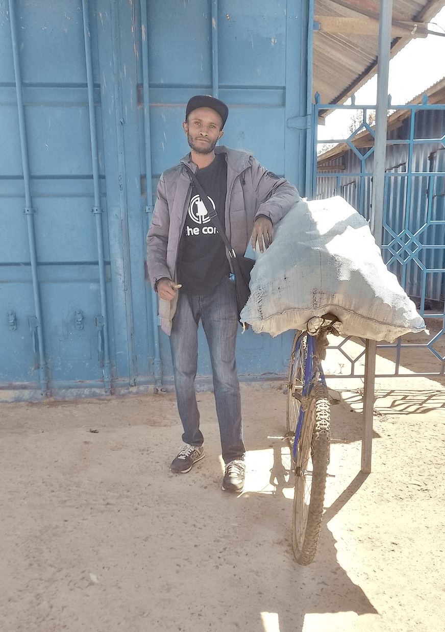 Makini with a sack of glass bottles