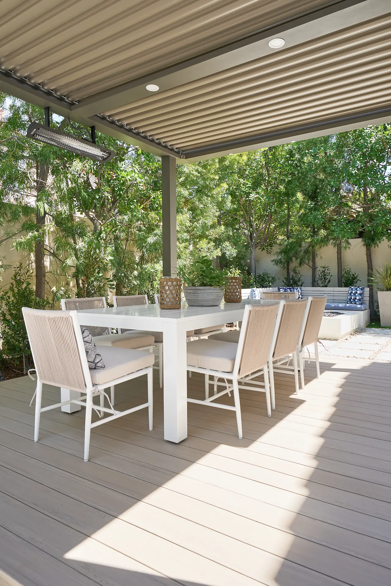 Portrait view of the exterior covered patio, showcasing seating arrangements and design in the Irvine Contemporary Coastal Remodel. Photo by Todd Huge.