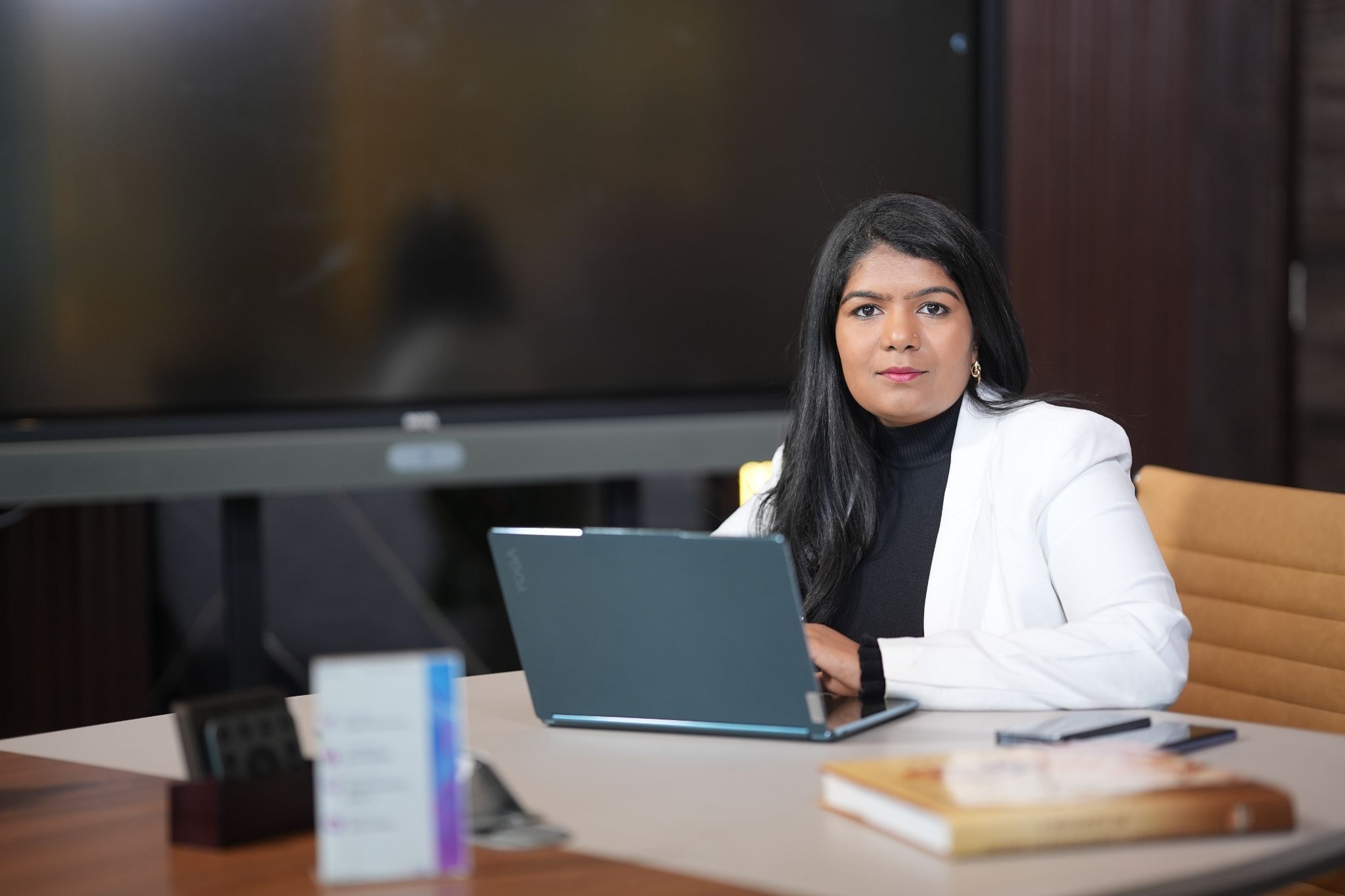 Ashwini Kotaru seated at office desk with laptop, leading global operations for Mobius by Gaian.