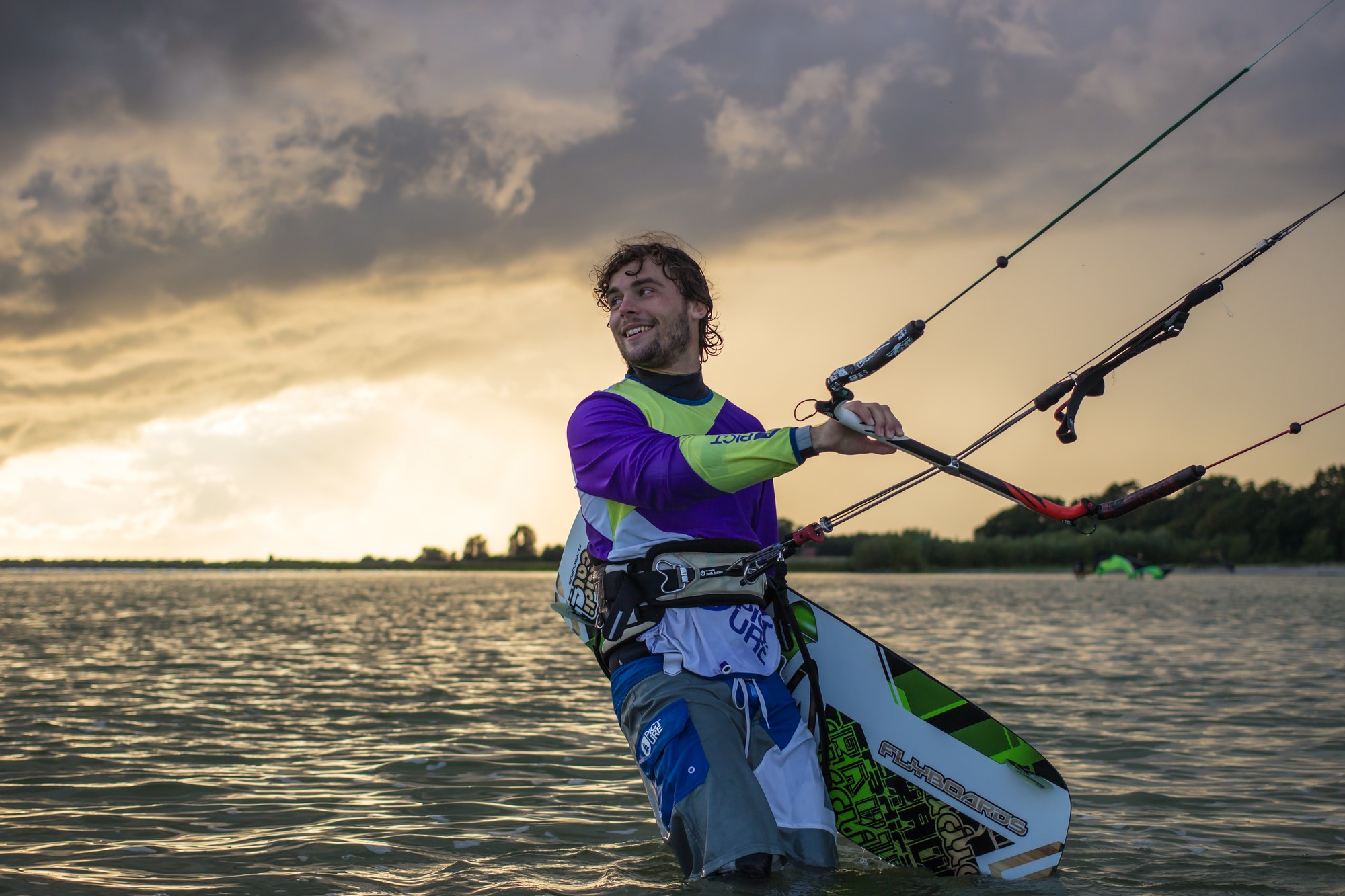 Kitesurfer on a lake in front of pre-alpine scenery in evening light — watersports belong to this region just as much as mountains and snow
