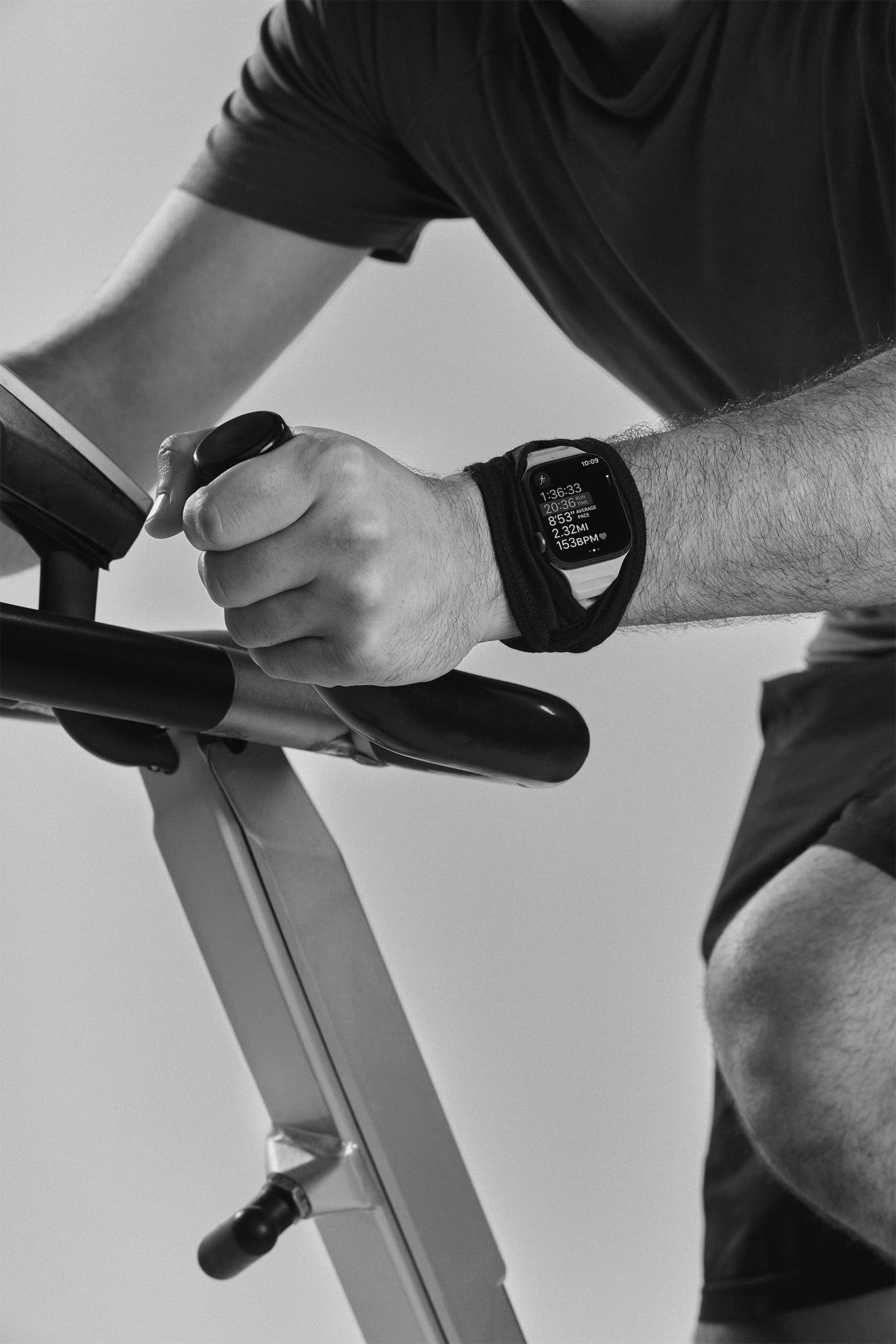 Man wearing olive green and orange sneakers with tall socks, standing on an urban street with a modern fence and skyscraper in the distance.