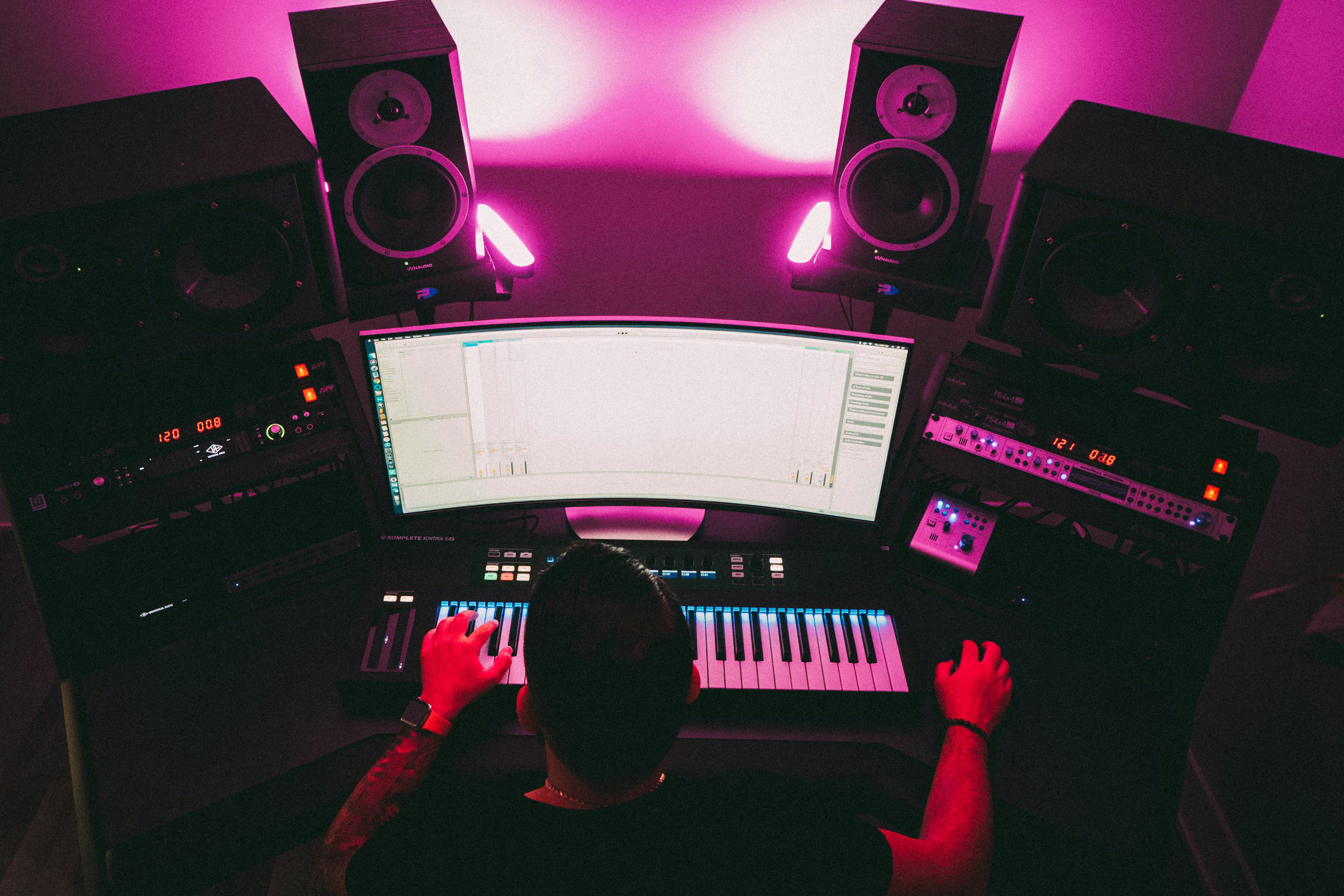 A male music producer in a studio setup creating music. Photo by Troy T on Unsplash