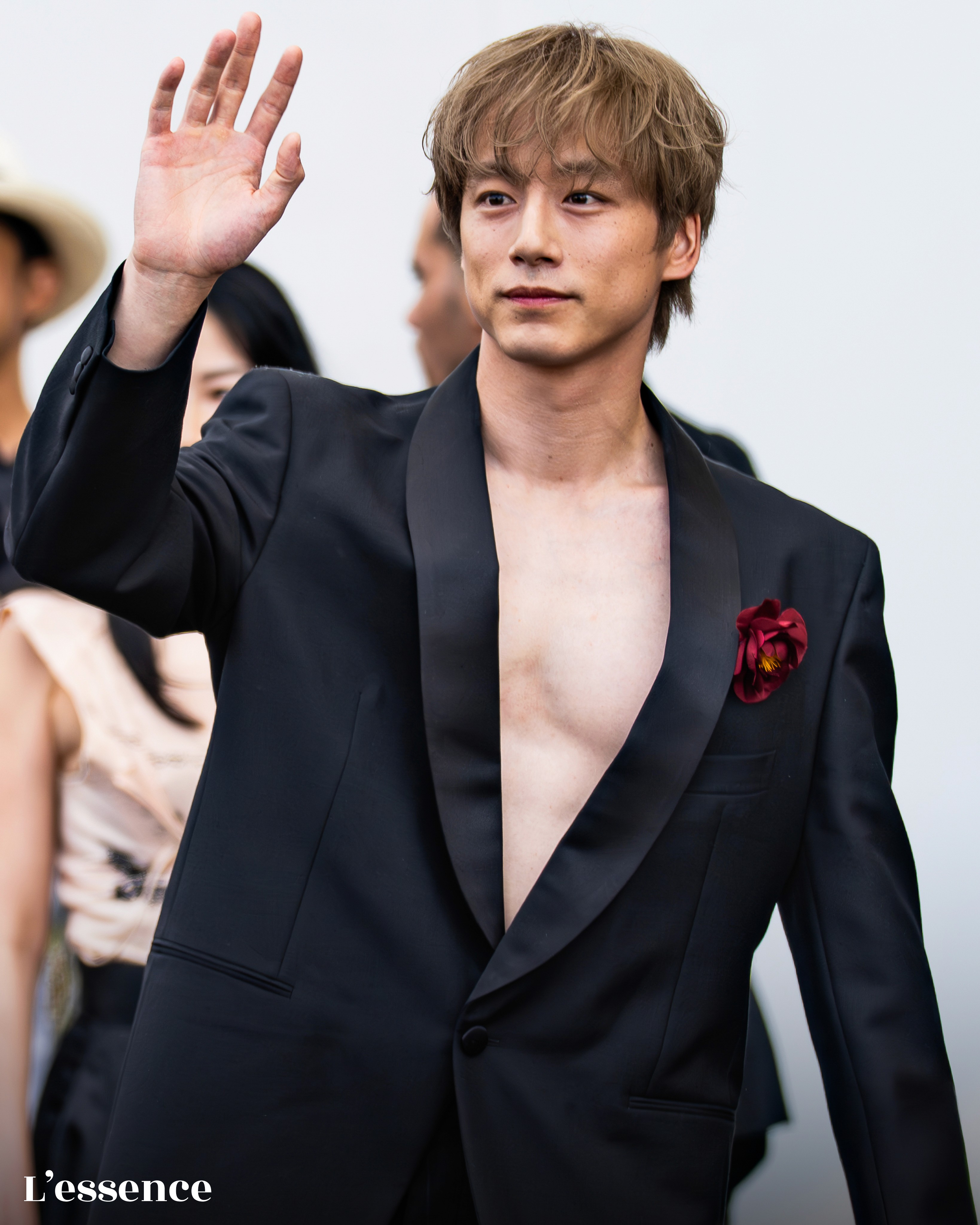 Kentaro Sakaguchi waves to fans at the Prada Men's Spring-Summer 2026 show at Milan Fashion Week.