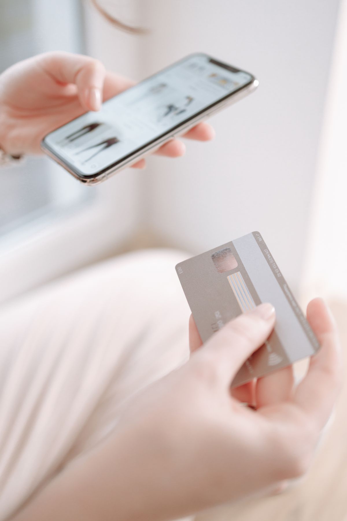 Mãos segurando smartphone e cartão para um pagamento digital rápido, ilustrando a entrega instantânea do prêmio.
