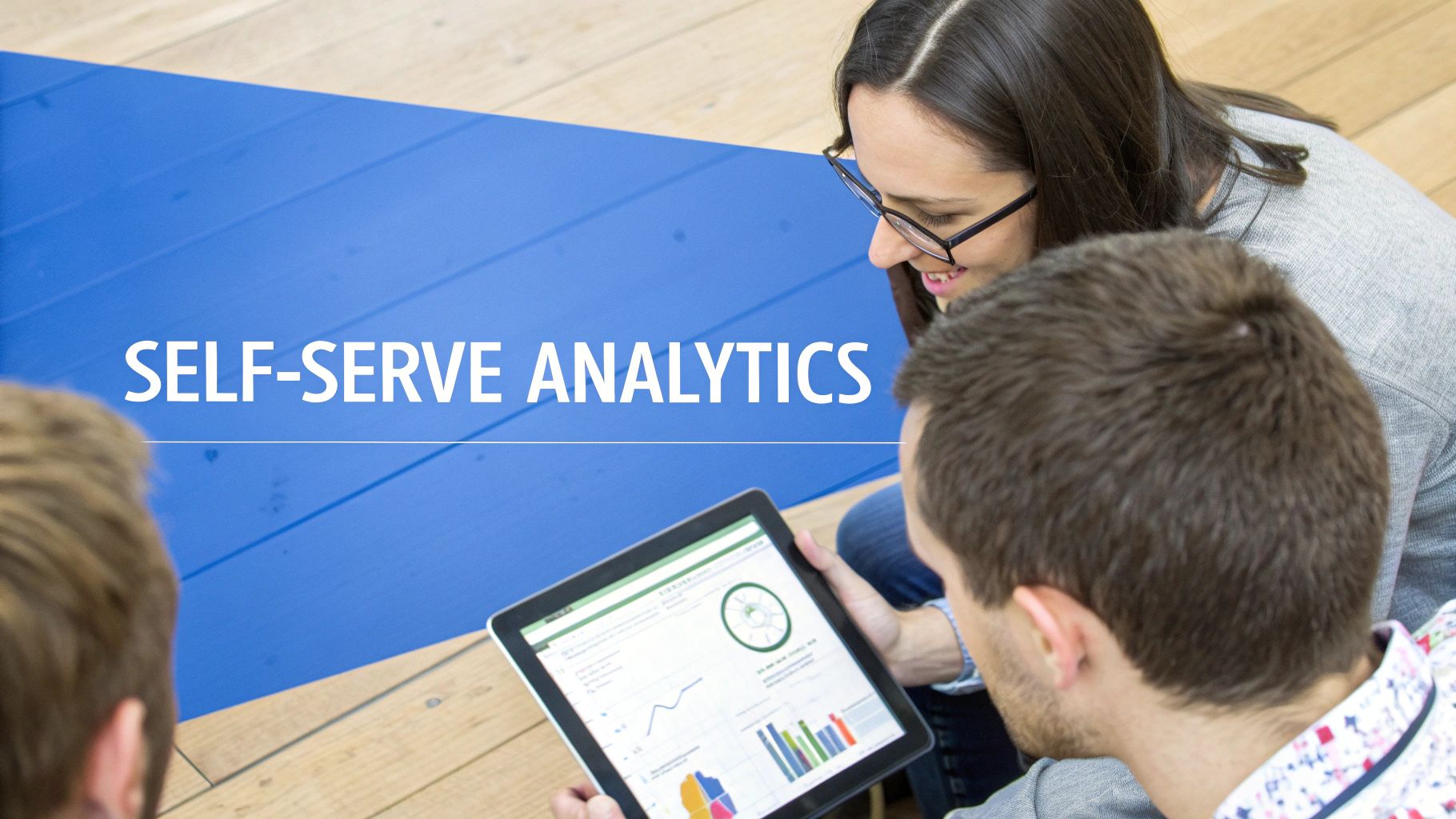Three people view a tablet with self-serve analytics dashboards, showcasing data insights and collaboration.