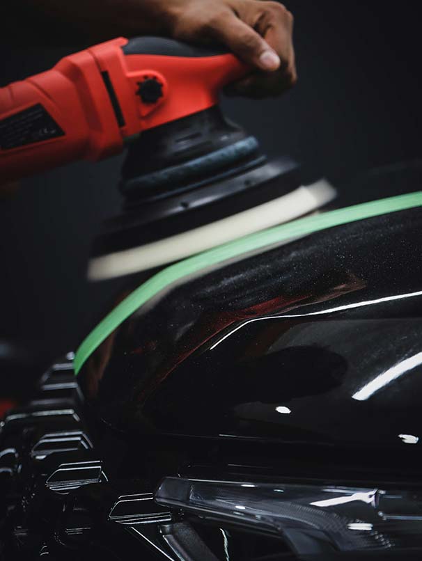 Car being buffed with buffing machine.