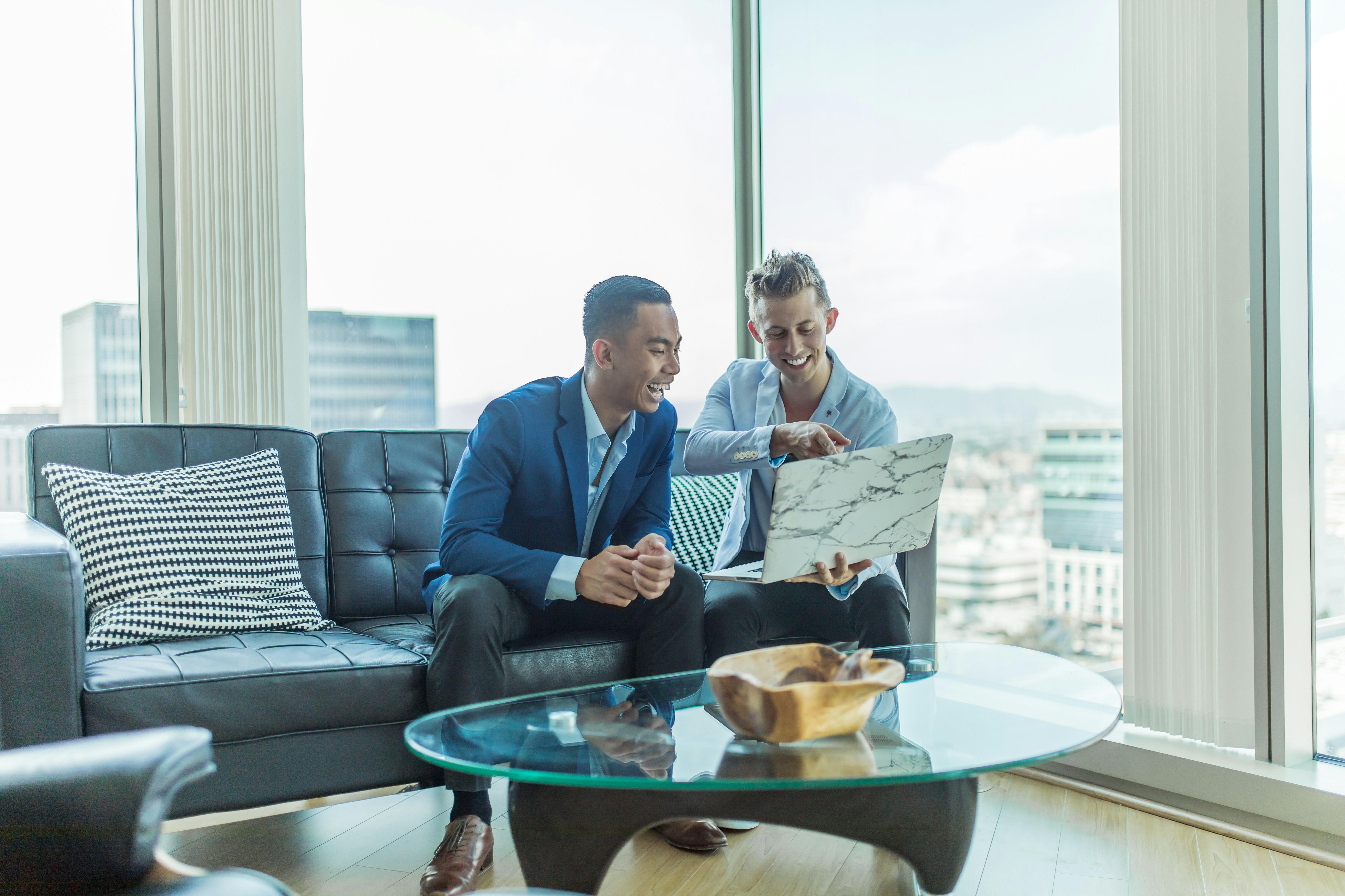 Two People Discussing on Laptop- trading analyst